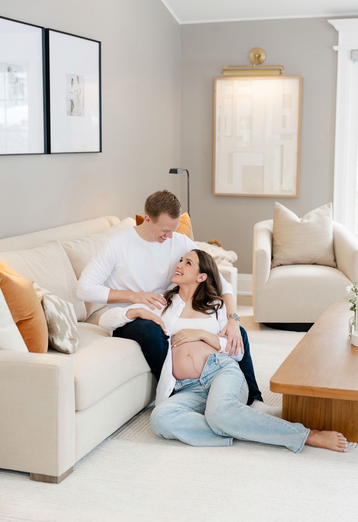 Couple sharing affectionate moments on white couch in modern living room.