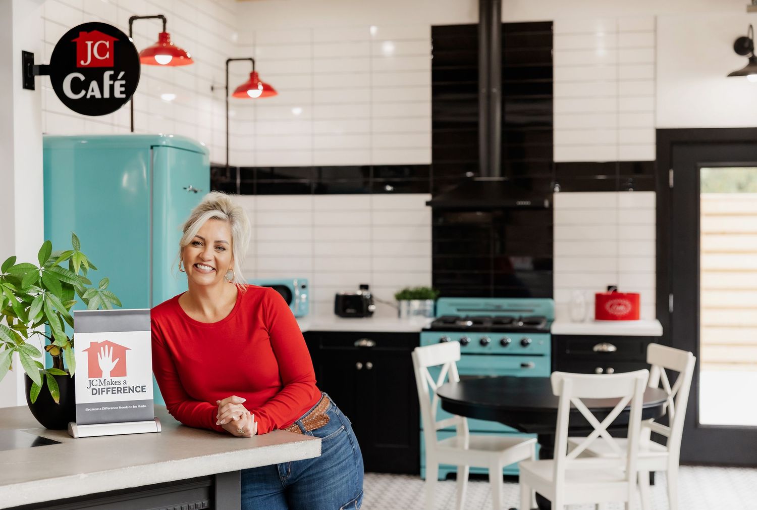 JC Cafe space with retro design elements including turquoise fridge and white subway tile walls.