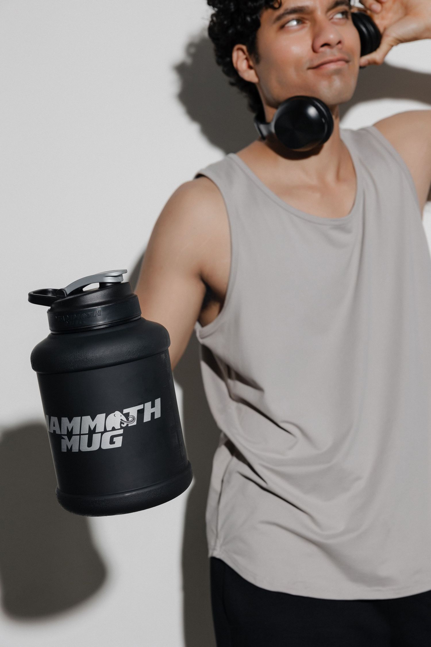 Close-up shots of fitness container with person in gray tank top posing.