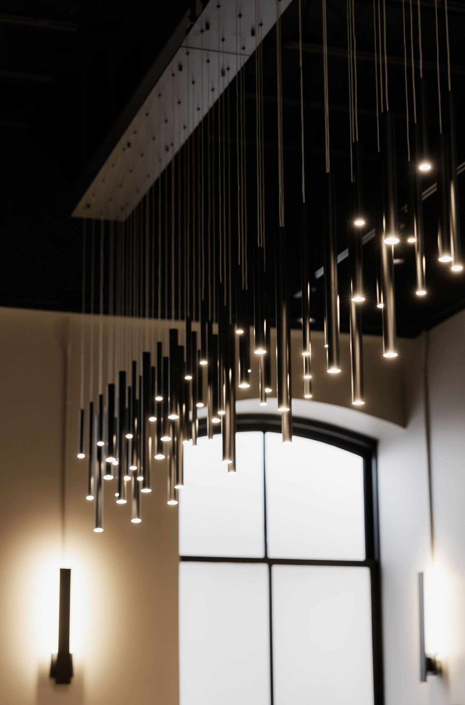 Modern pendant lighting installation with multiple hanging lights creating dramatic ambiance.
