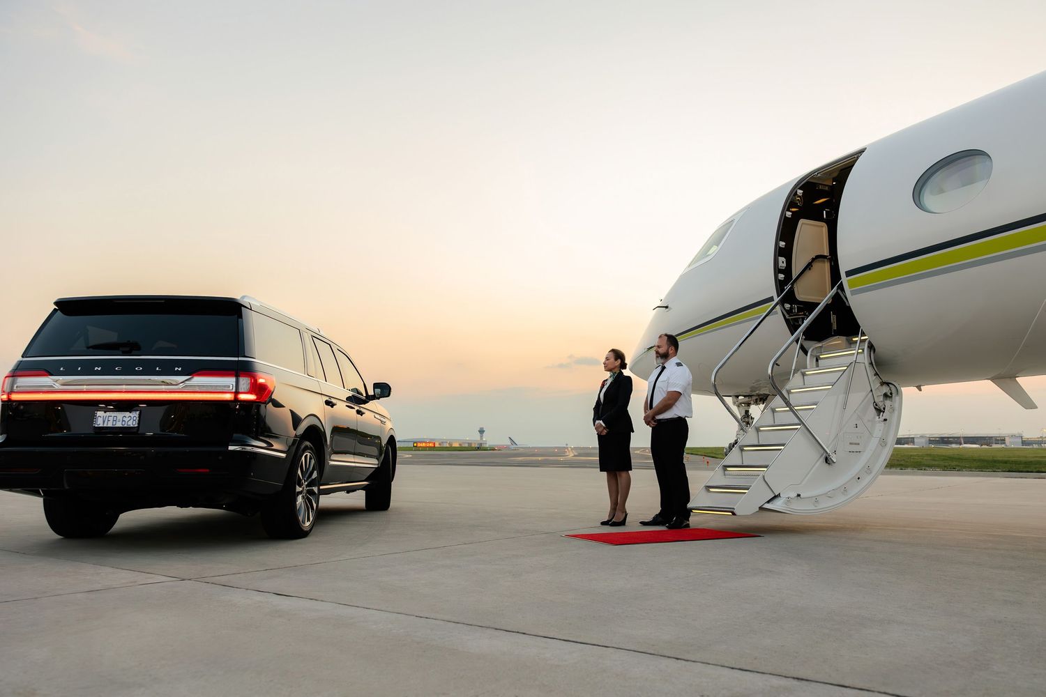 Luxury cars and private aircraft lined up on tarmac during golden hour.