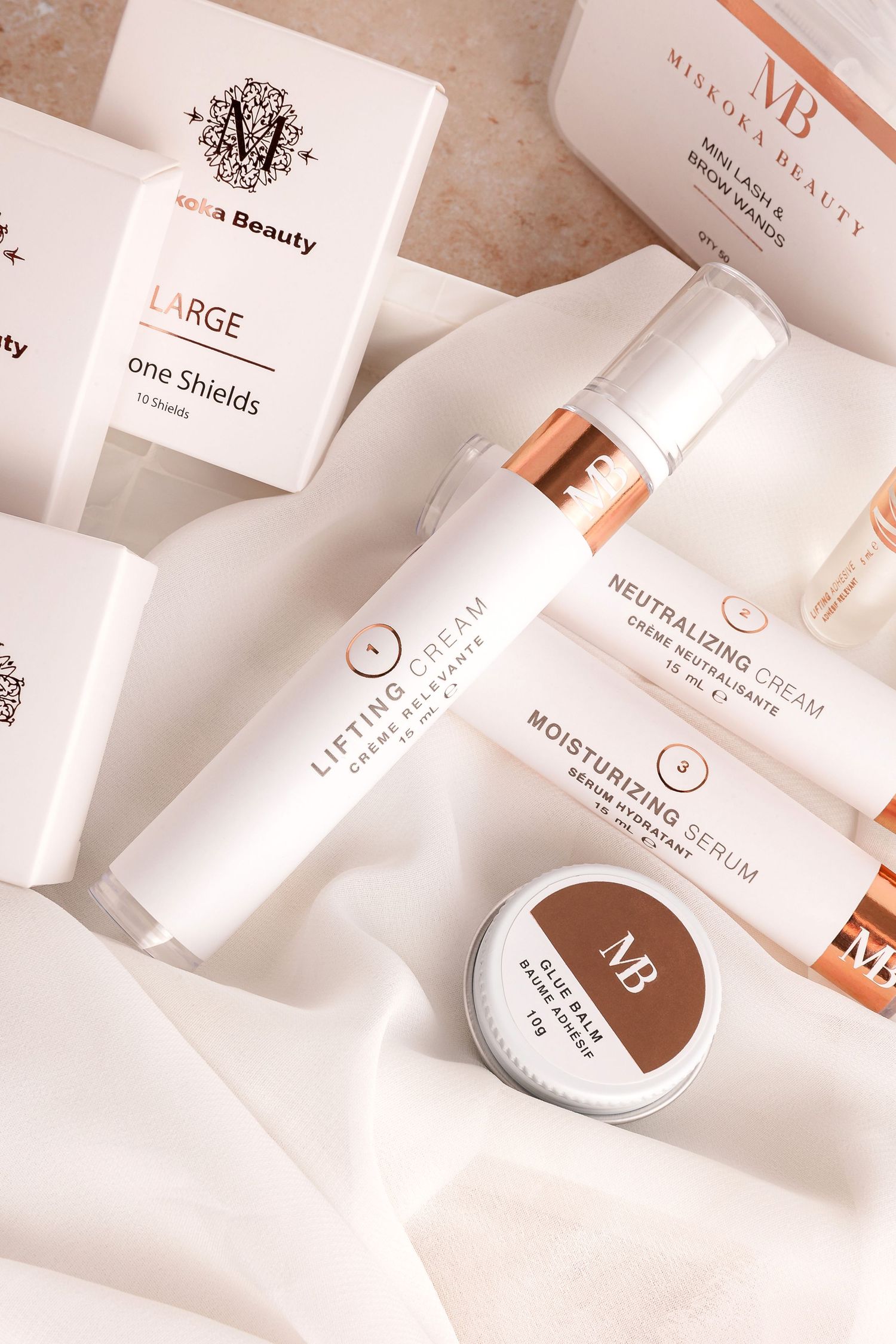 Minimalist beauty product collection featuring white and rose gold branding elements.
