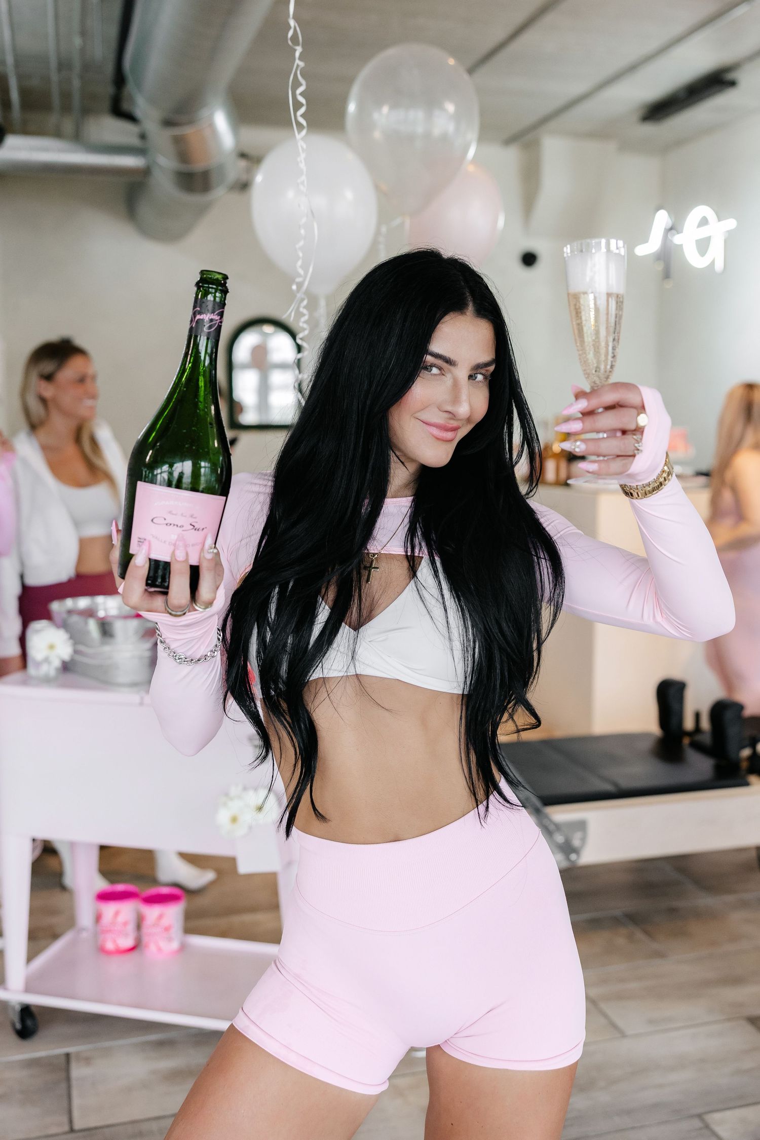 Bright fitness studio decorated with white balloons and pink accents.