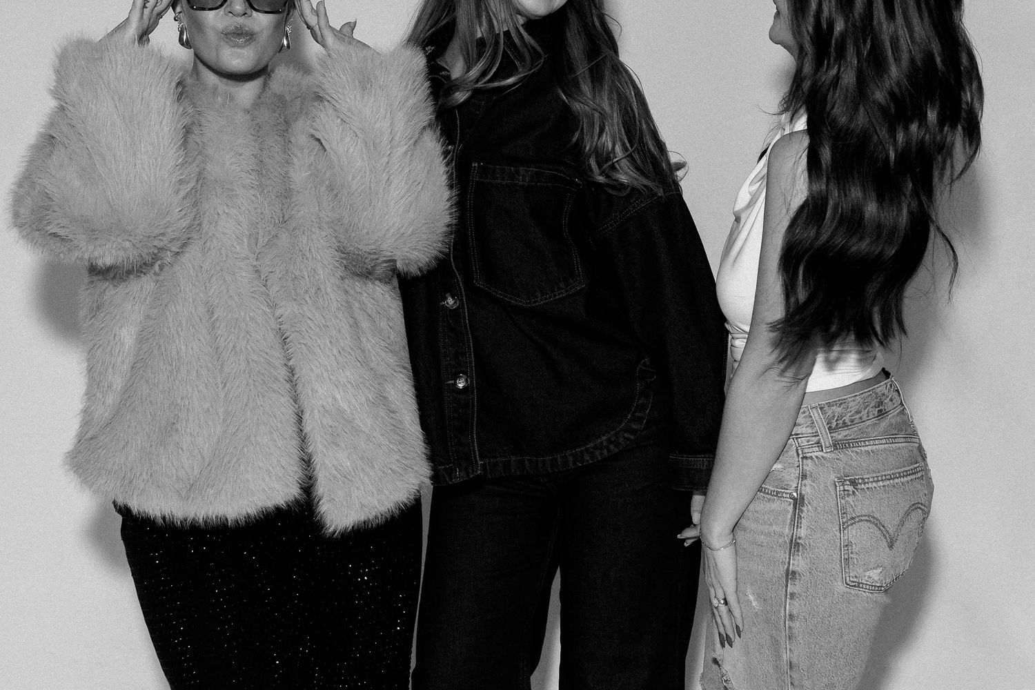 Black and white fashion photo showing models in denim and fur outfits.