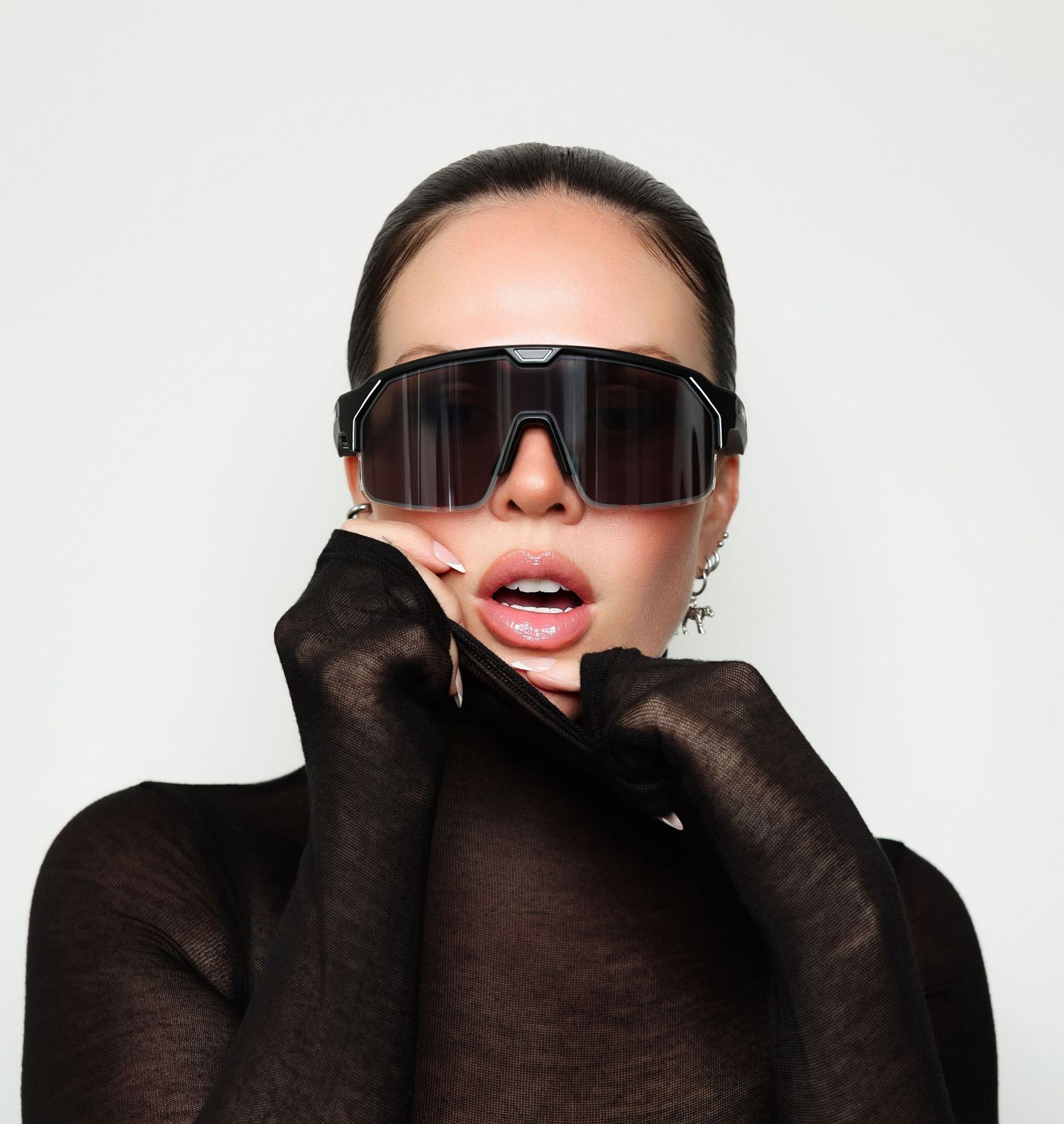 Person wearing black sunglasses and gloves smiling against white background in three similar poses.