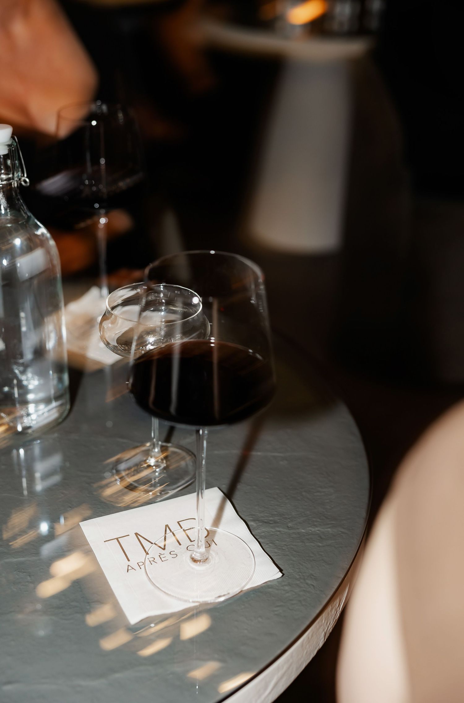 Overhead view of champagne glasses and handwritten notes on a dark table surface.