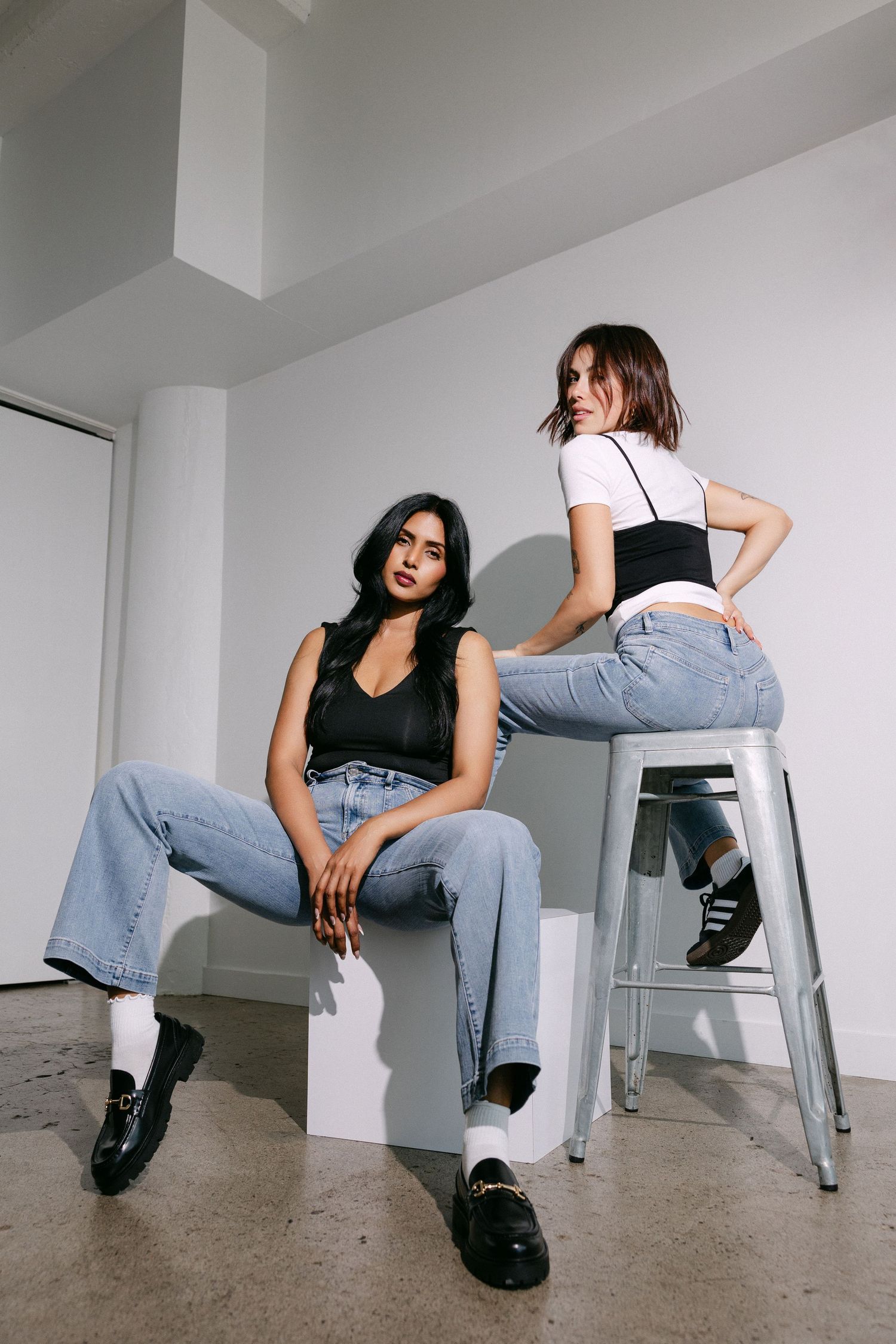 Modern fashion editorial with metal chair featuring casual denim and black outfit combinations.