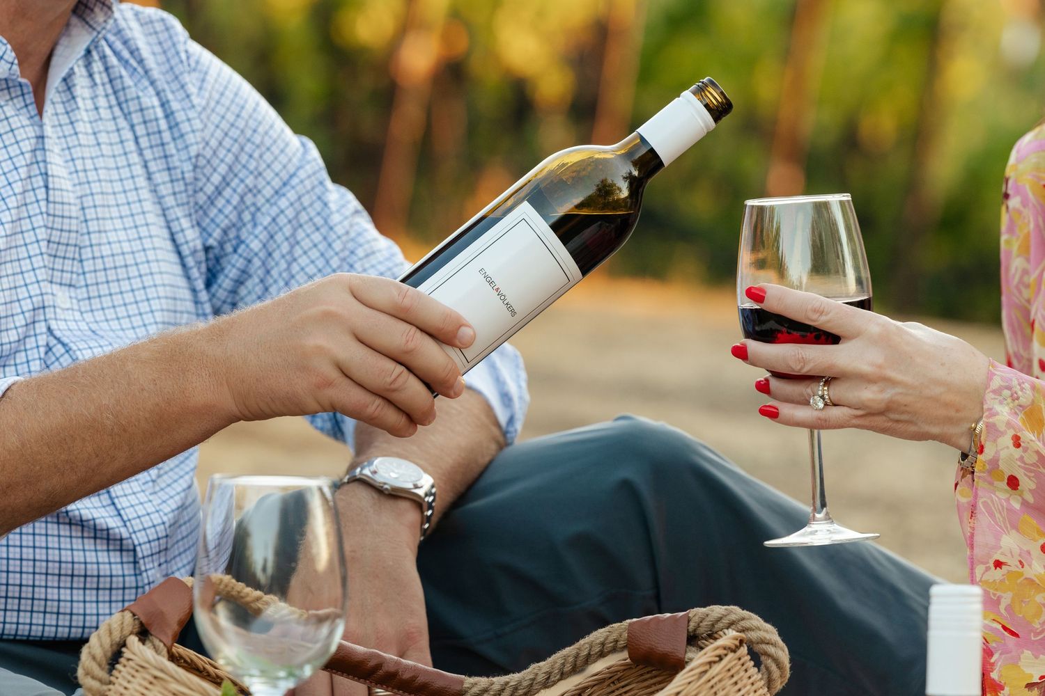 People enjoying wine and conversation at outdoor gathering.