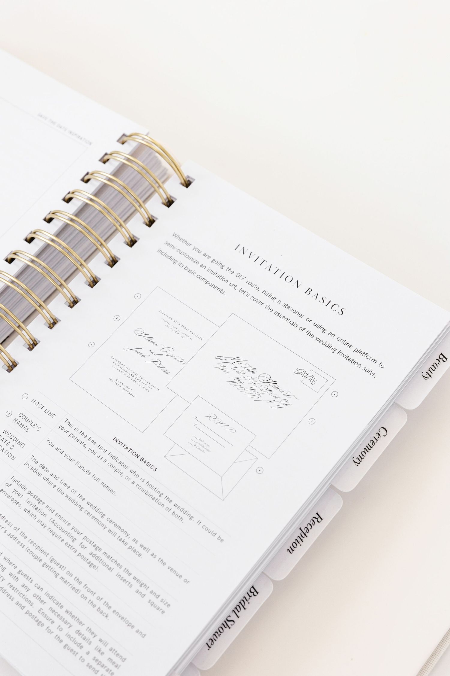 Wedding invitation planning pages with signature spaces in white spiral-bound planner.