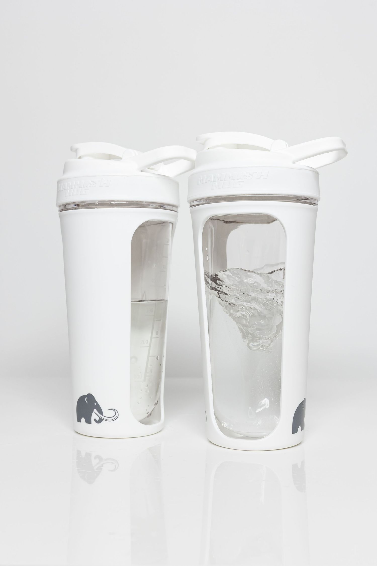 White ceramic mugs with small elephant motif displayed in a row on white surface.