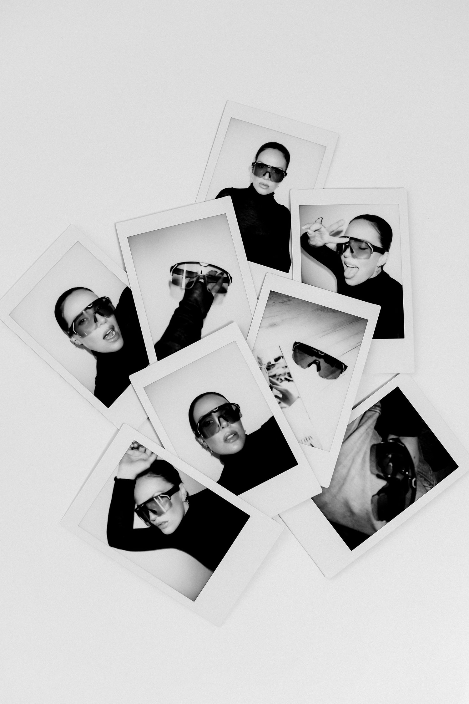 Scattered polaroid photographs displaying modern eyewear campaign shots on white background.