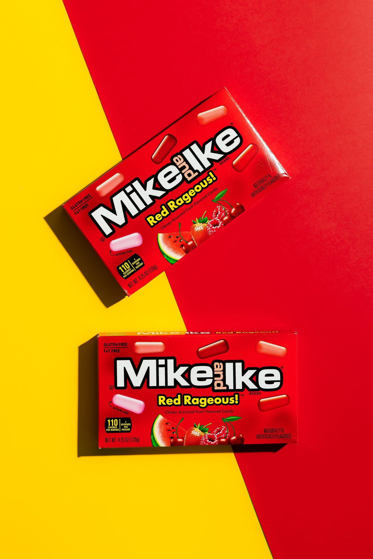 Two boxes of Mike and Ike Red Rageous candy on red and yellow background.