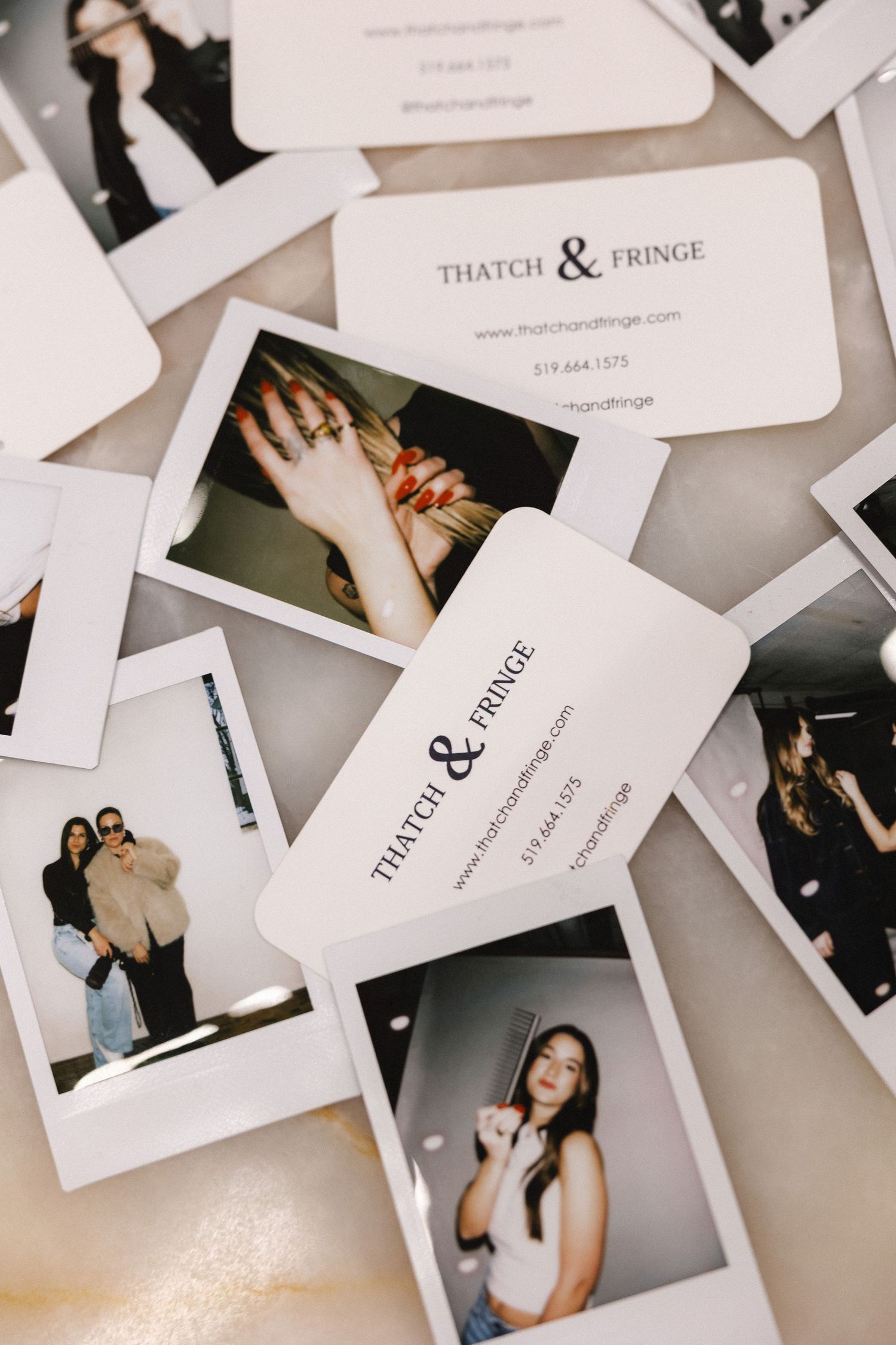 Collection of scattered business cards and photographs on a light surface.