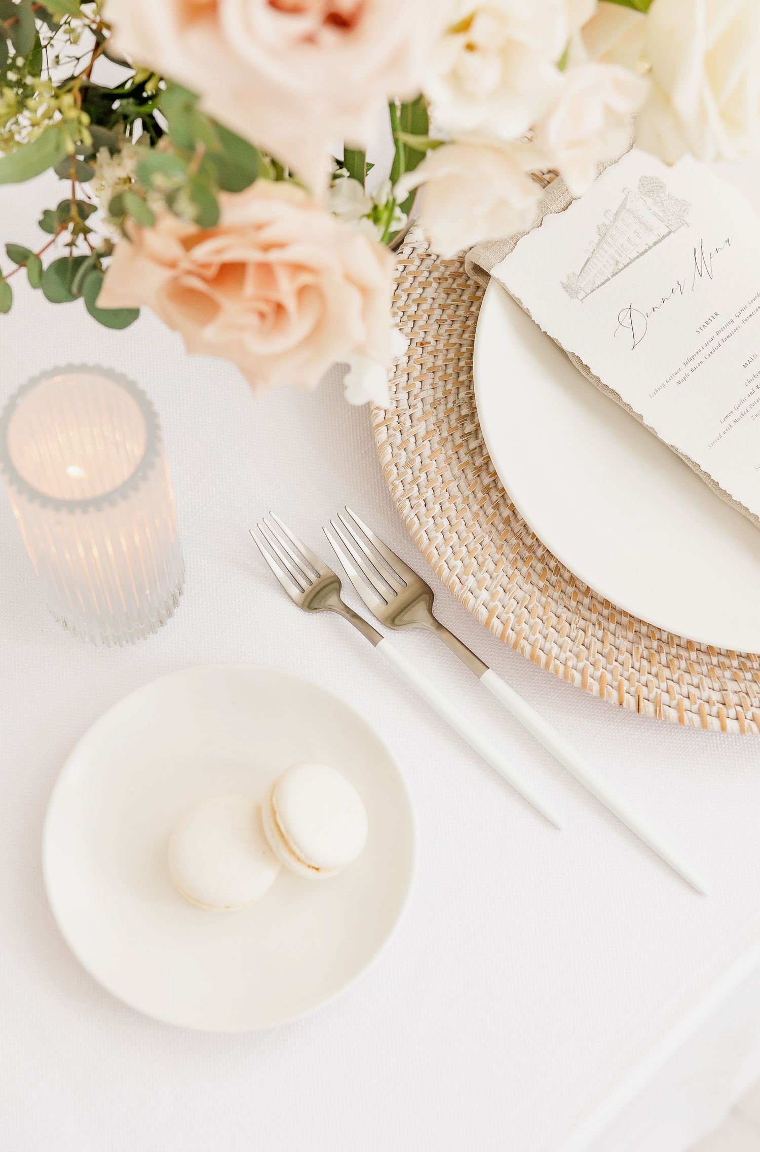 Elegant table setting with textured charger plates and peach floral arrangements.