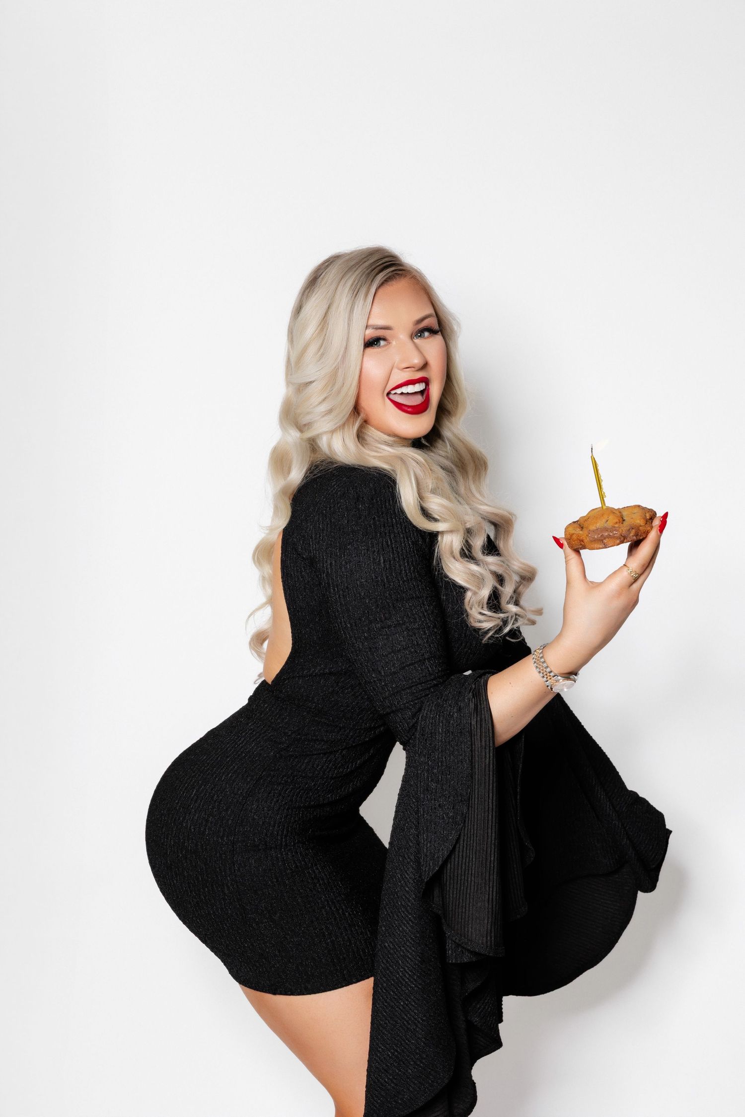 A series of dynamic poses in a black outfit against a white backdrop showcasing glamorous styling and movement.