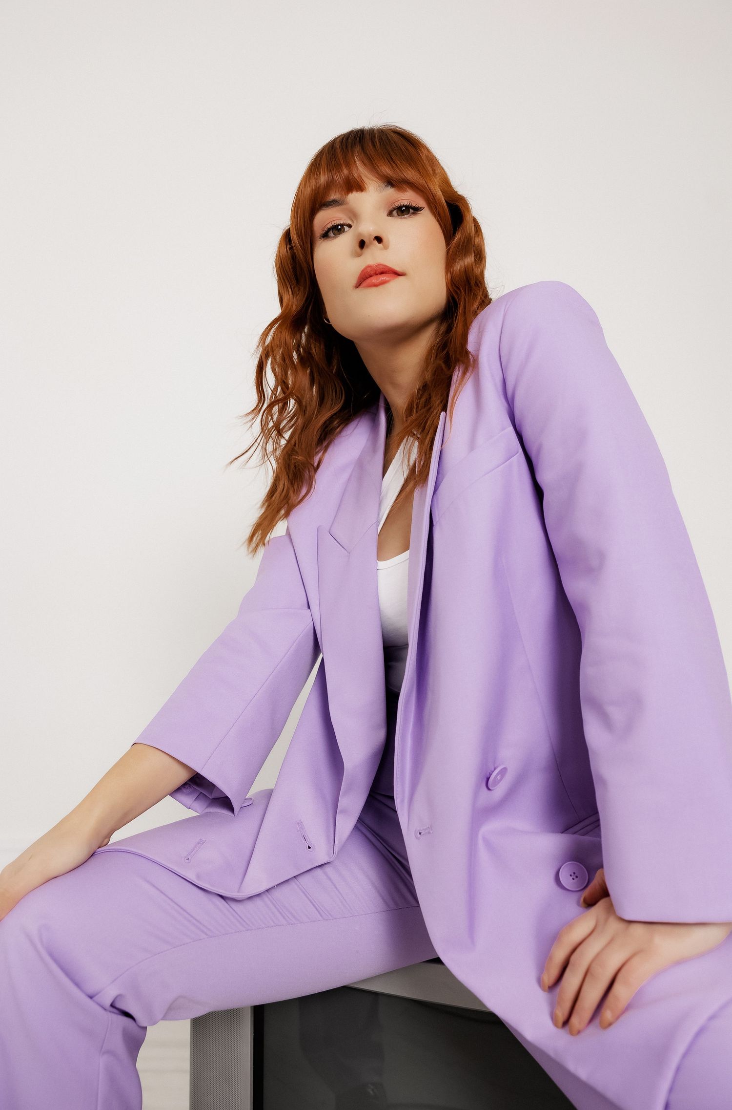 Stylish lavender business suit photographed against minimalist white background.