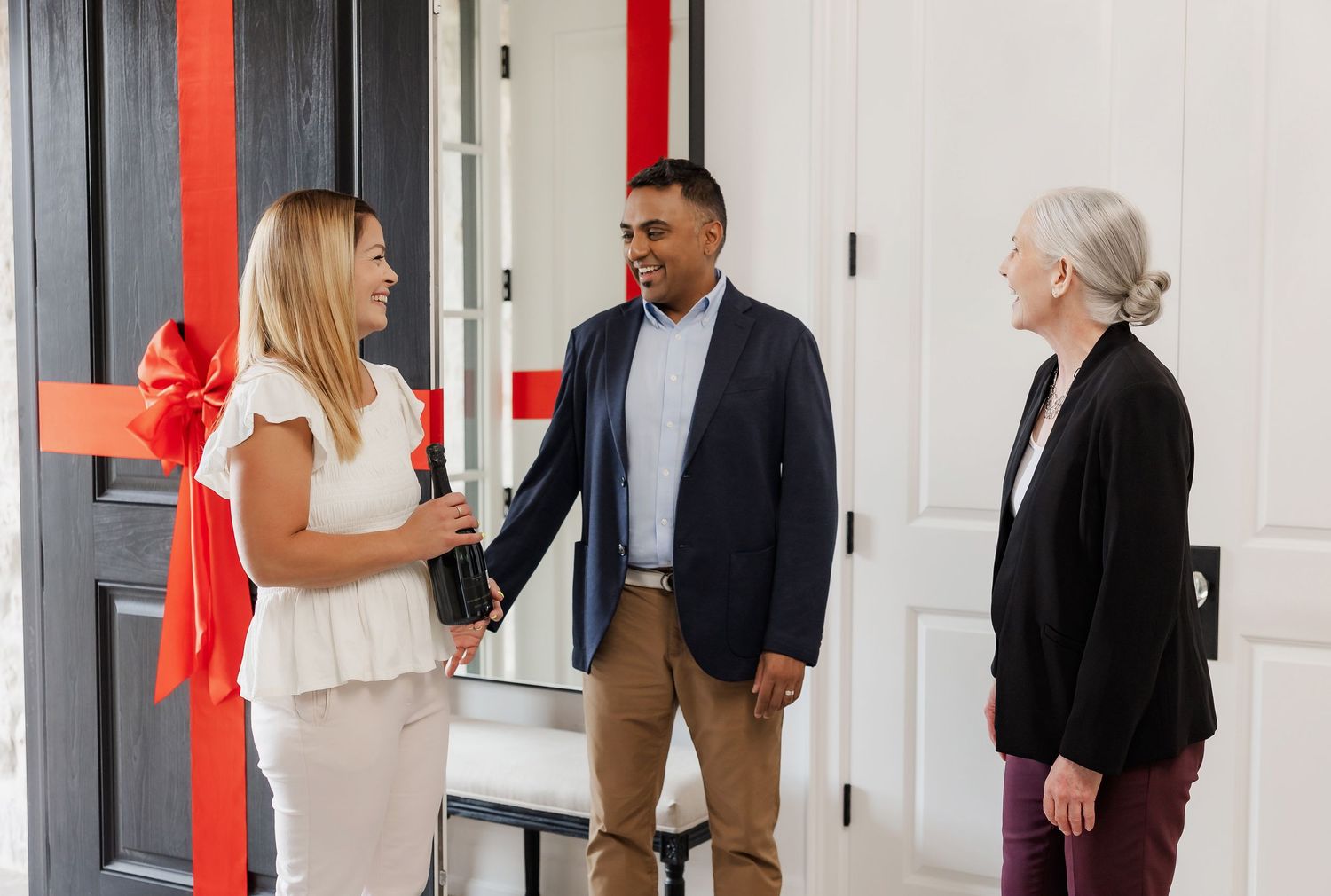 Group of real estate professionals meeting in bright modern office hallway.