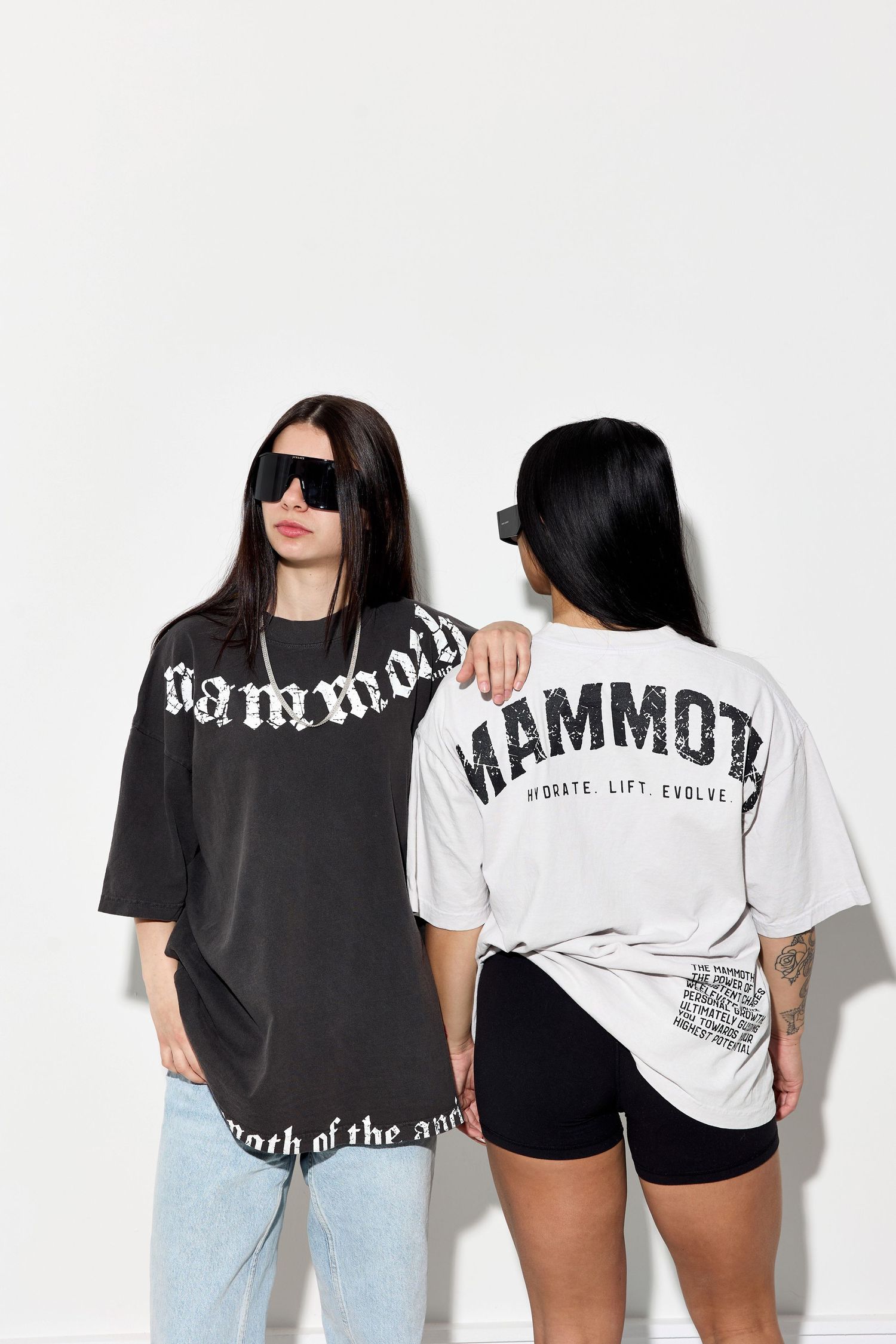 Models pose in contrasting black and white Mammoth shirts showing brand messaging.