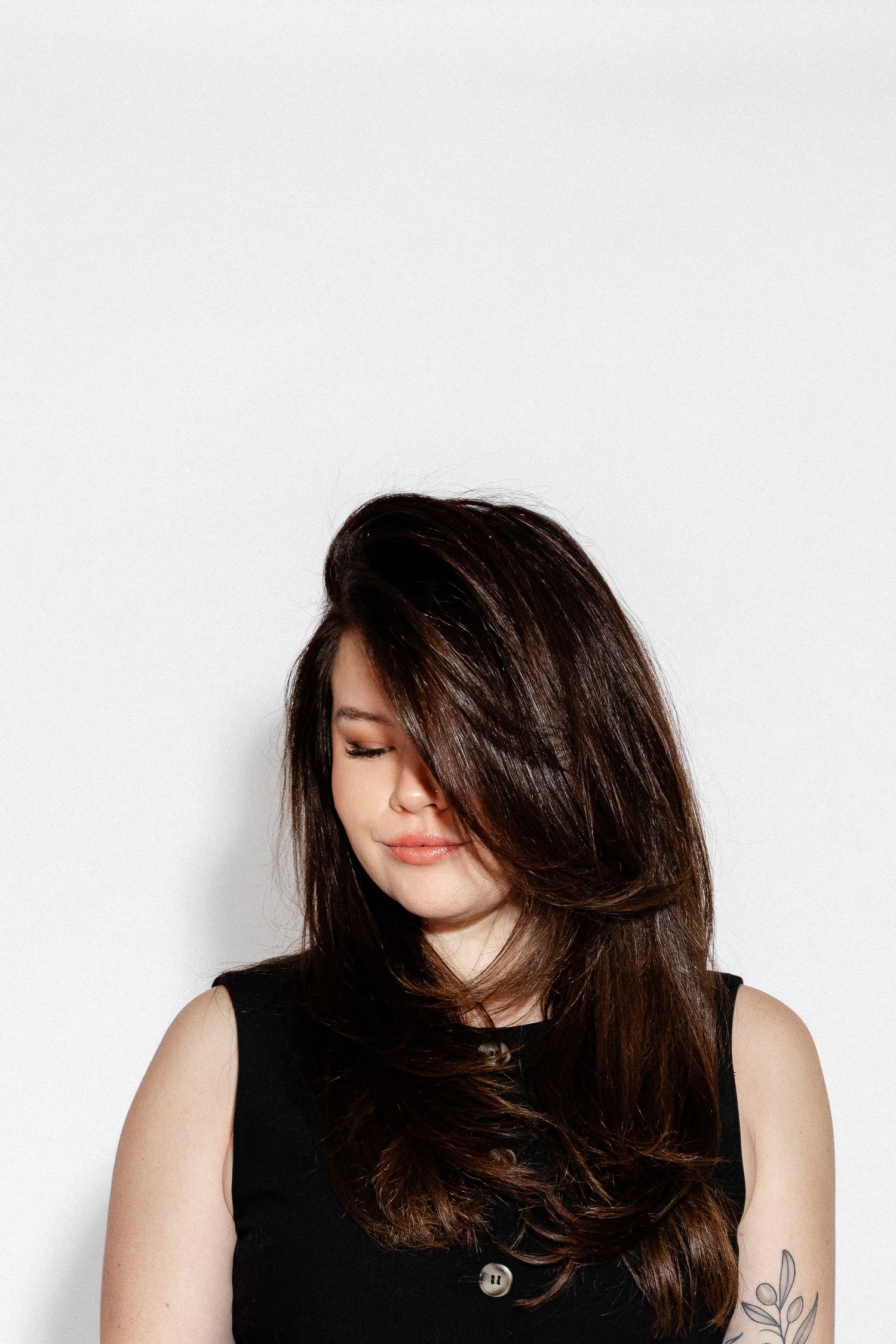 Artistic portrait series showing dynamic hair movement against white background.