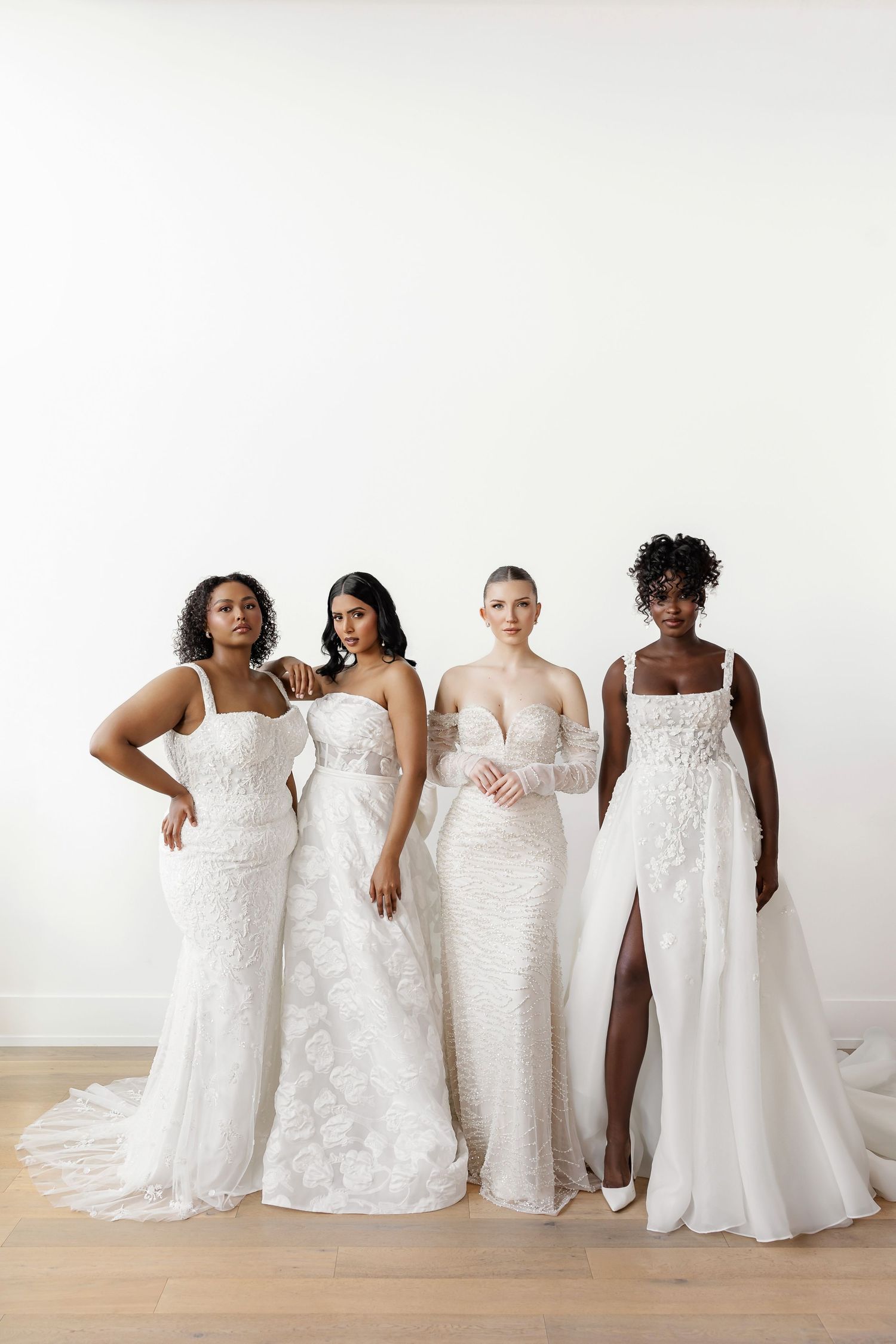 Four wedding dresses displayed together against a white backdrop showcasing different bridal styles.