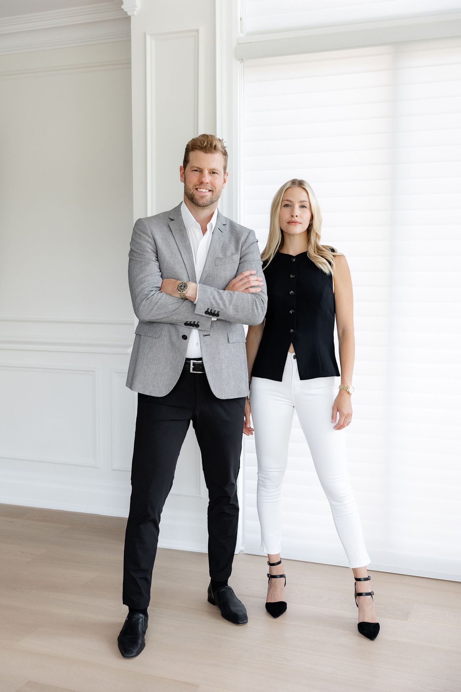 Professional business team in coordinated outfits standing in bright modern office space.
