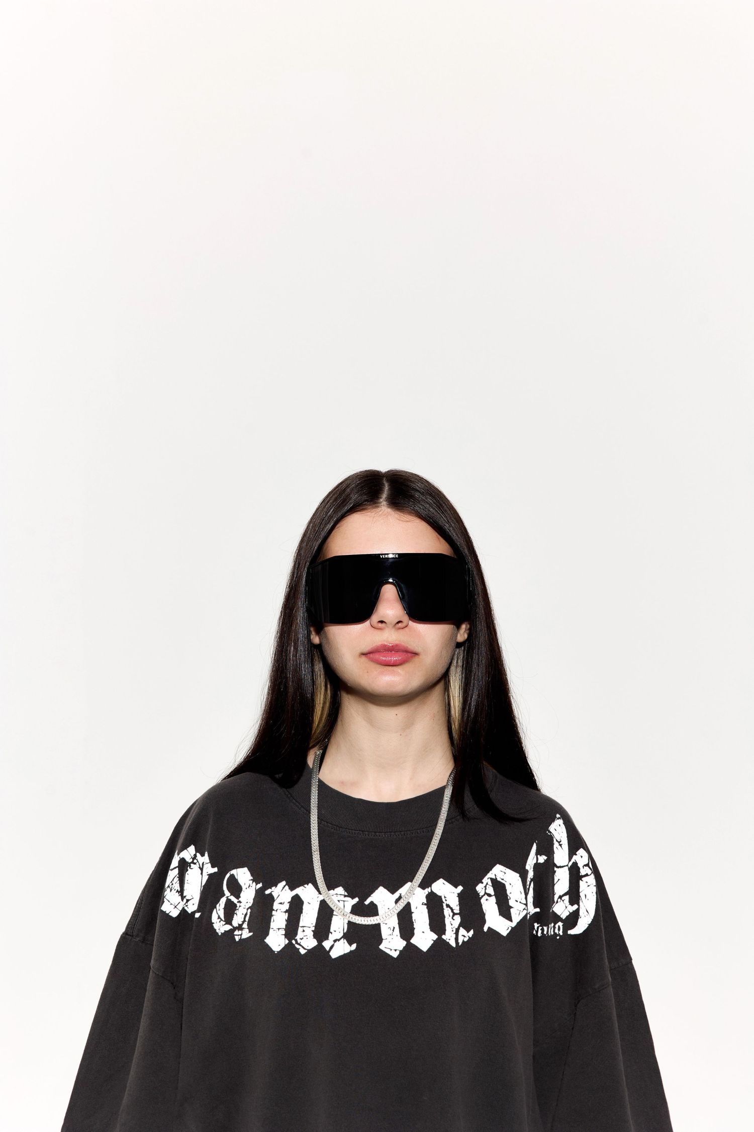 Close-up shots of model wearing black Mammoth shirt and sunglasses against white backdrop.
