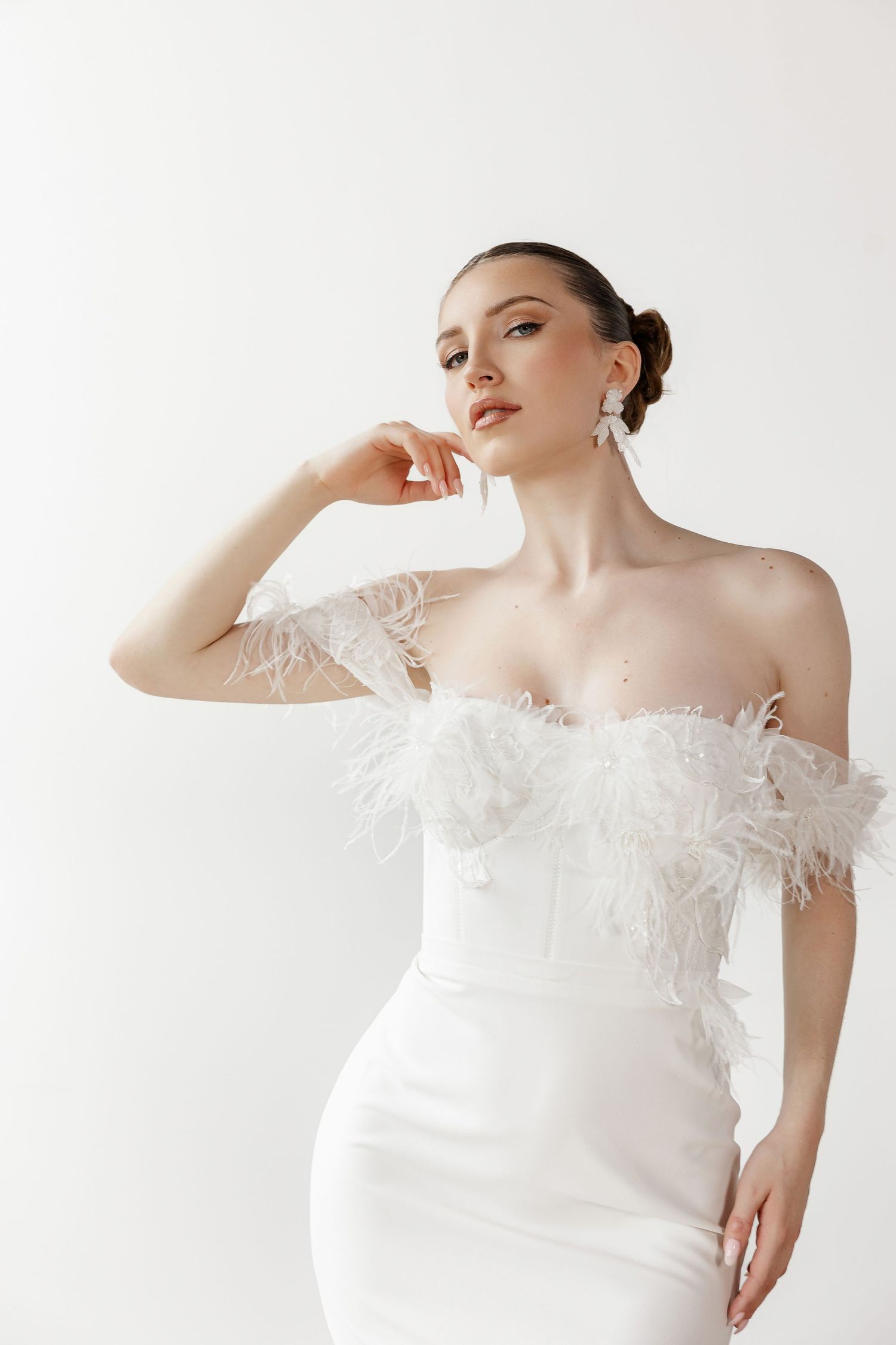 Elegant white feathered wedding dress with off-shoulder design shown in multiple angles against white background.