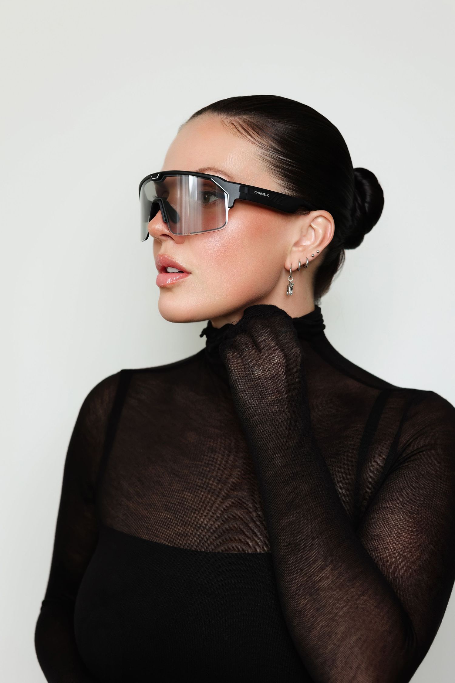 Fashion portrait with modern sunglasses and sheer black turtleneck.