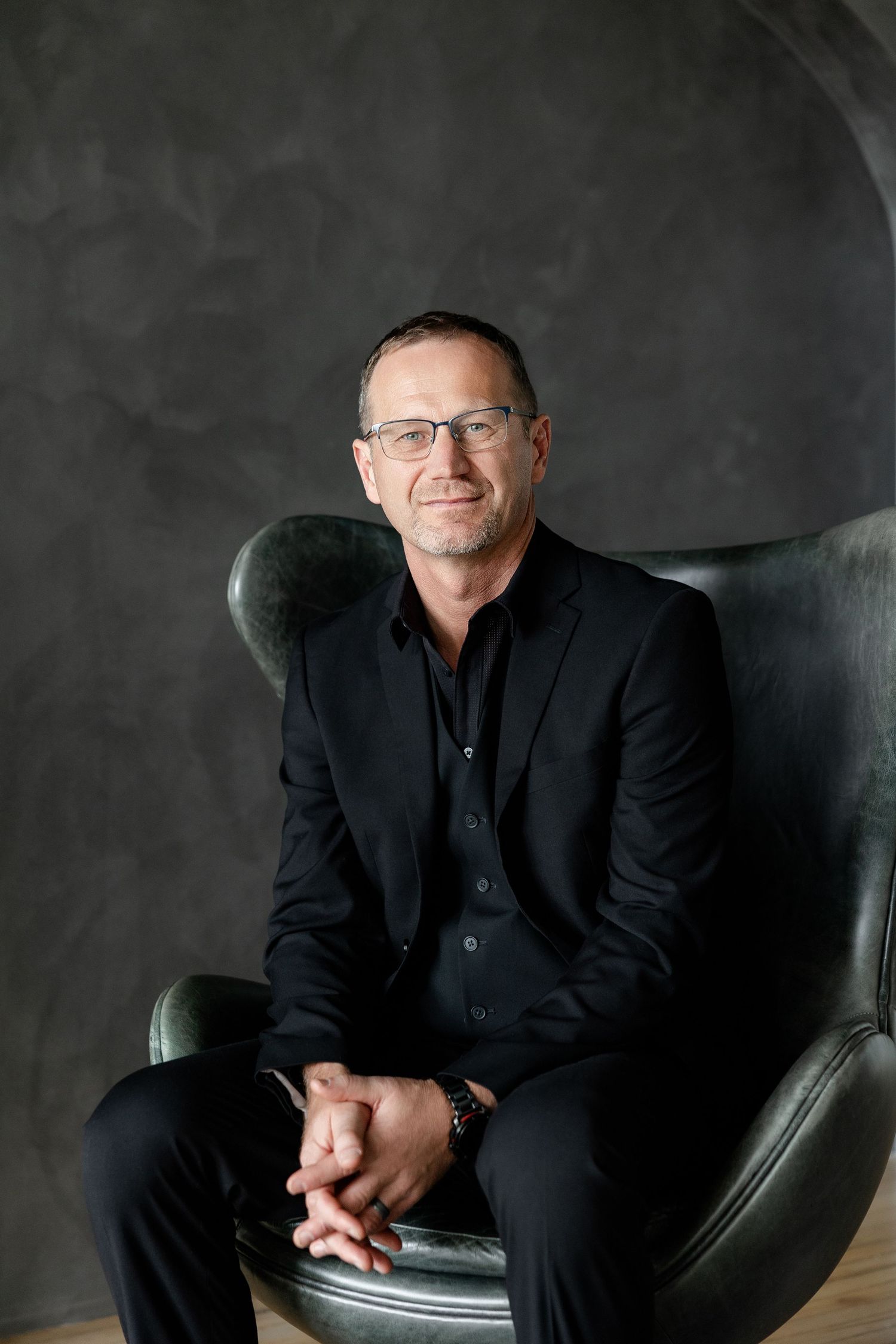 Professional portrait series against dark background showing different expressions and poses.