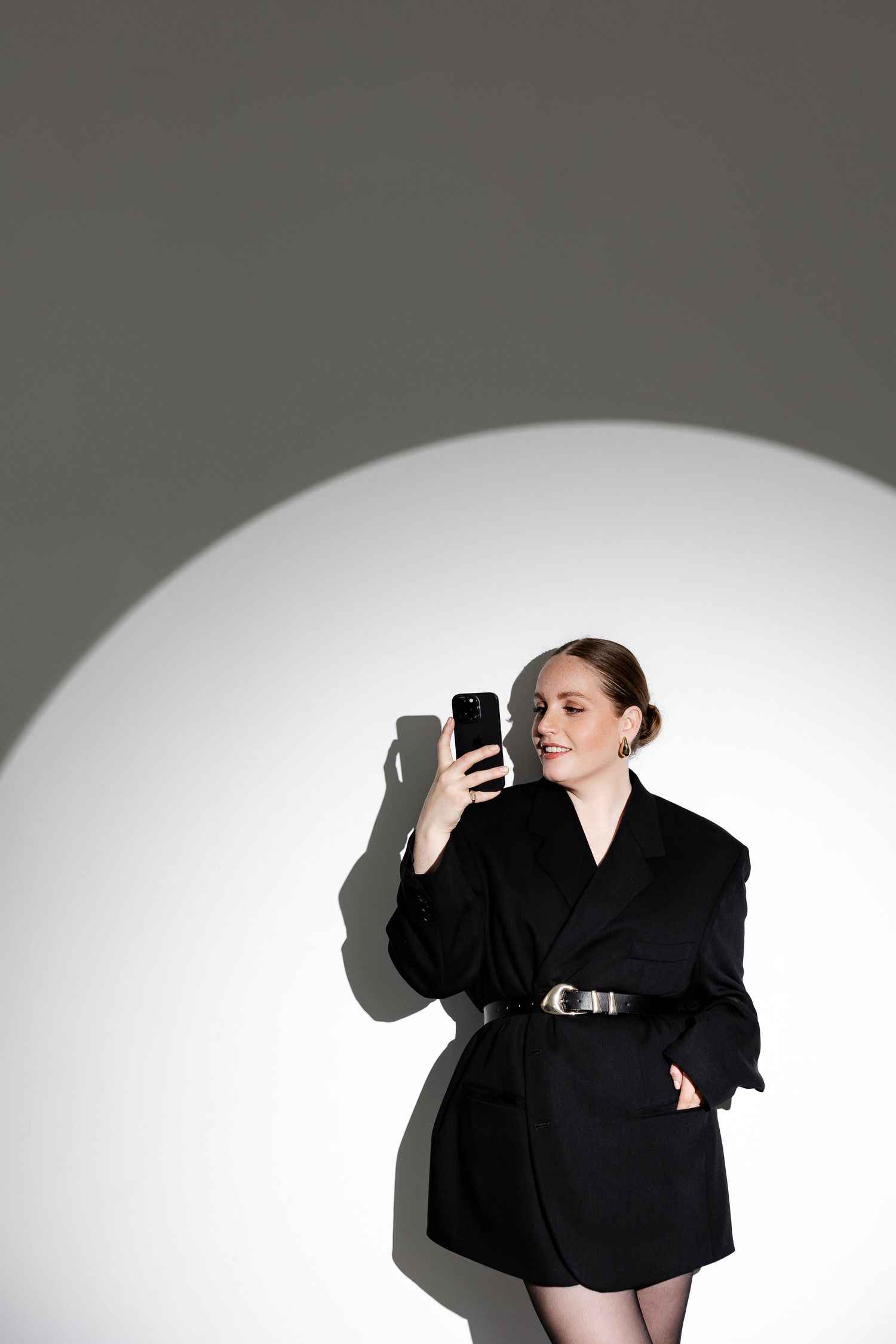 Contemporary fashion portrait with strong shadows and minimalist styling.