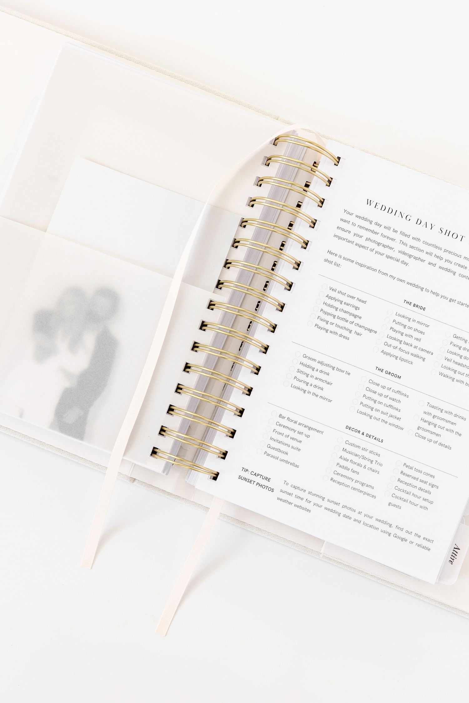 Wedding planning guide pages with text and checklists in white spiral notebook.
