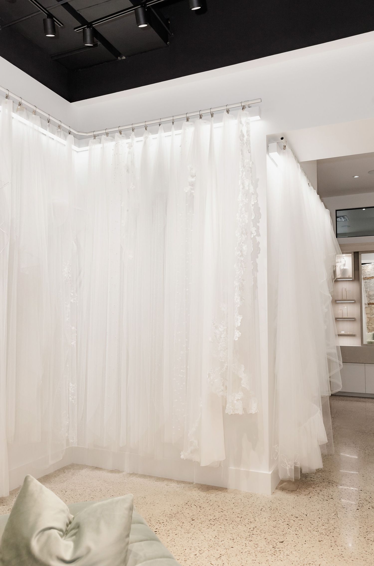 Bright retail space with white sheer curtains dividing the room into sections.