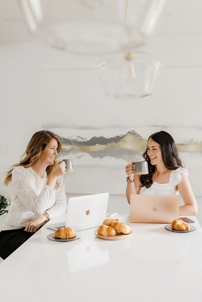 Friends enjoying pastries and conversation at a bright white table setting.