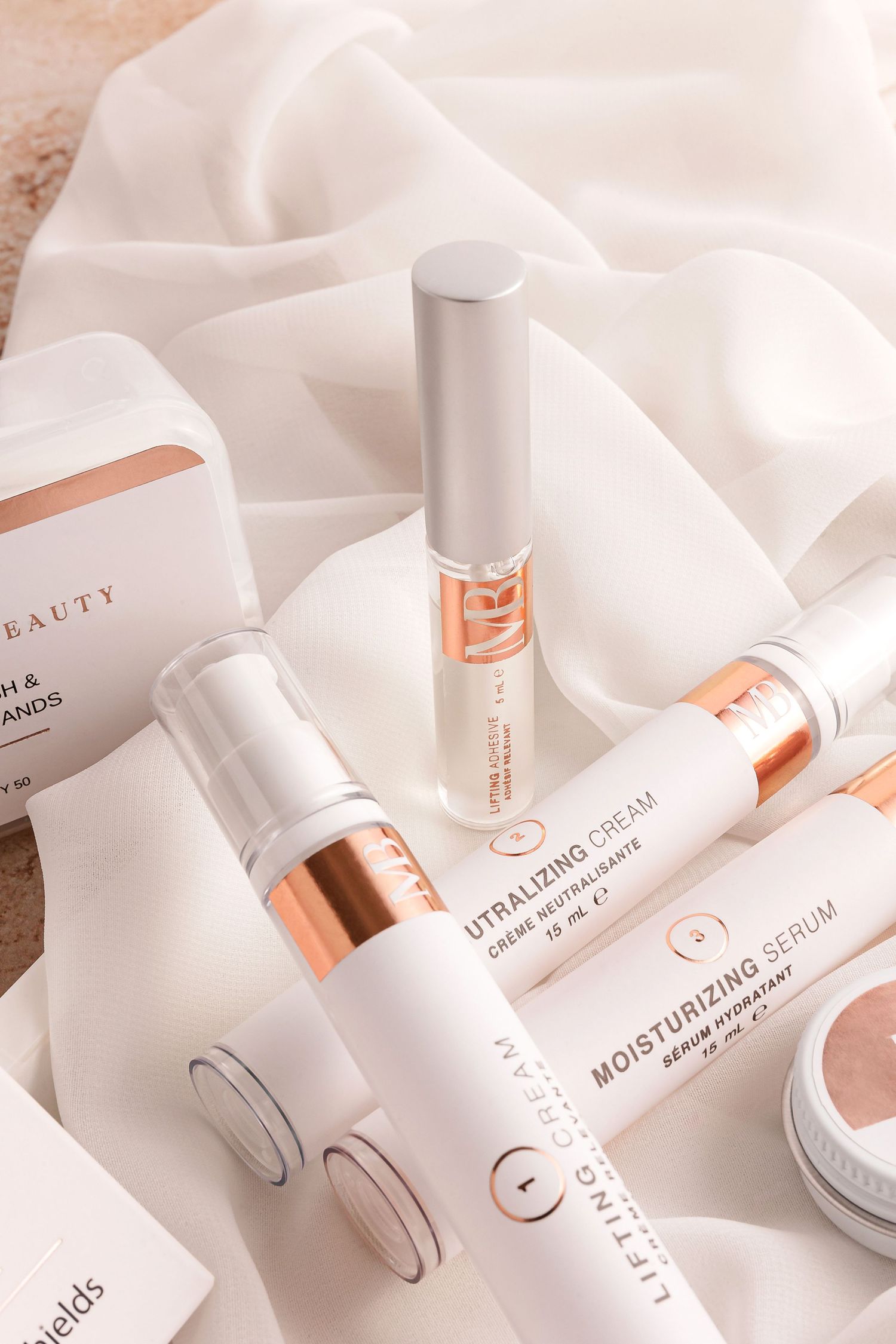 Elegant white skincare bottles and packaging with rose gold accents.