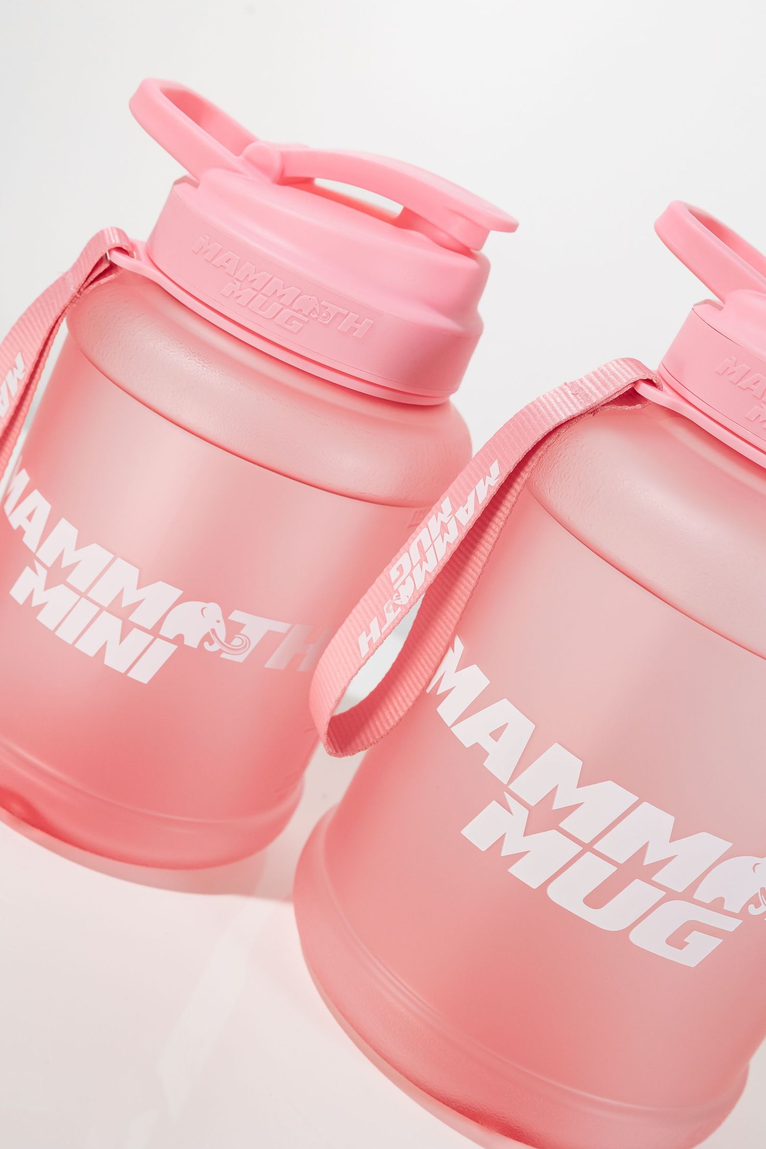 Multiple angles of a pink Mammoth Mini protein shaker showing bottle design and branding.