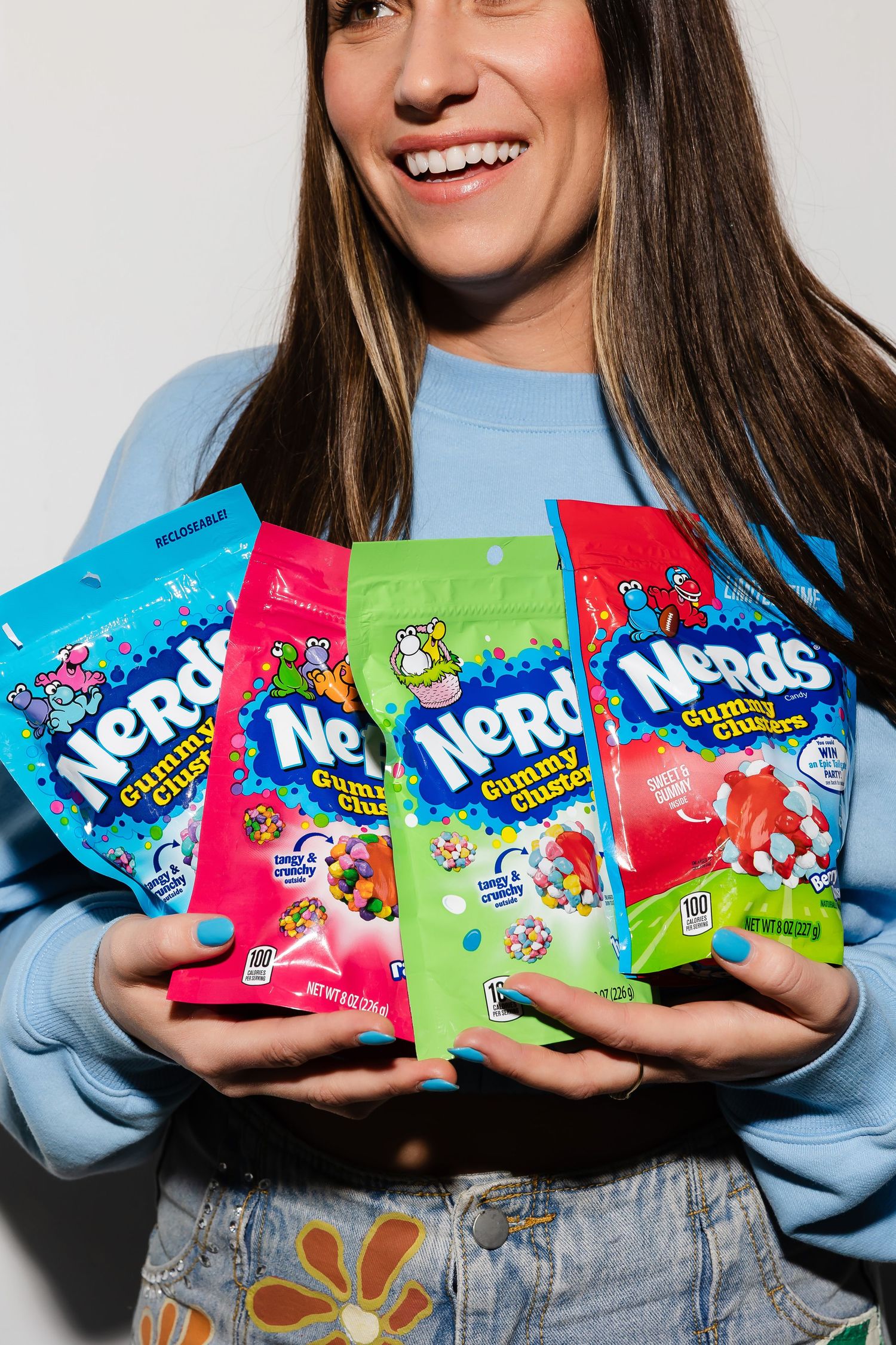 Collection of colorful Nerds candy packages displayed in hands.