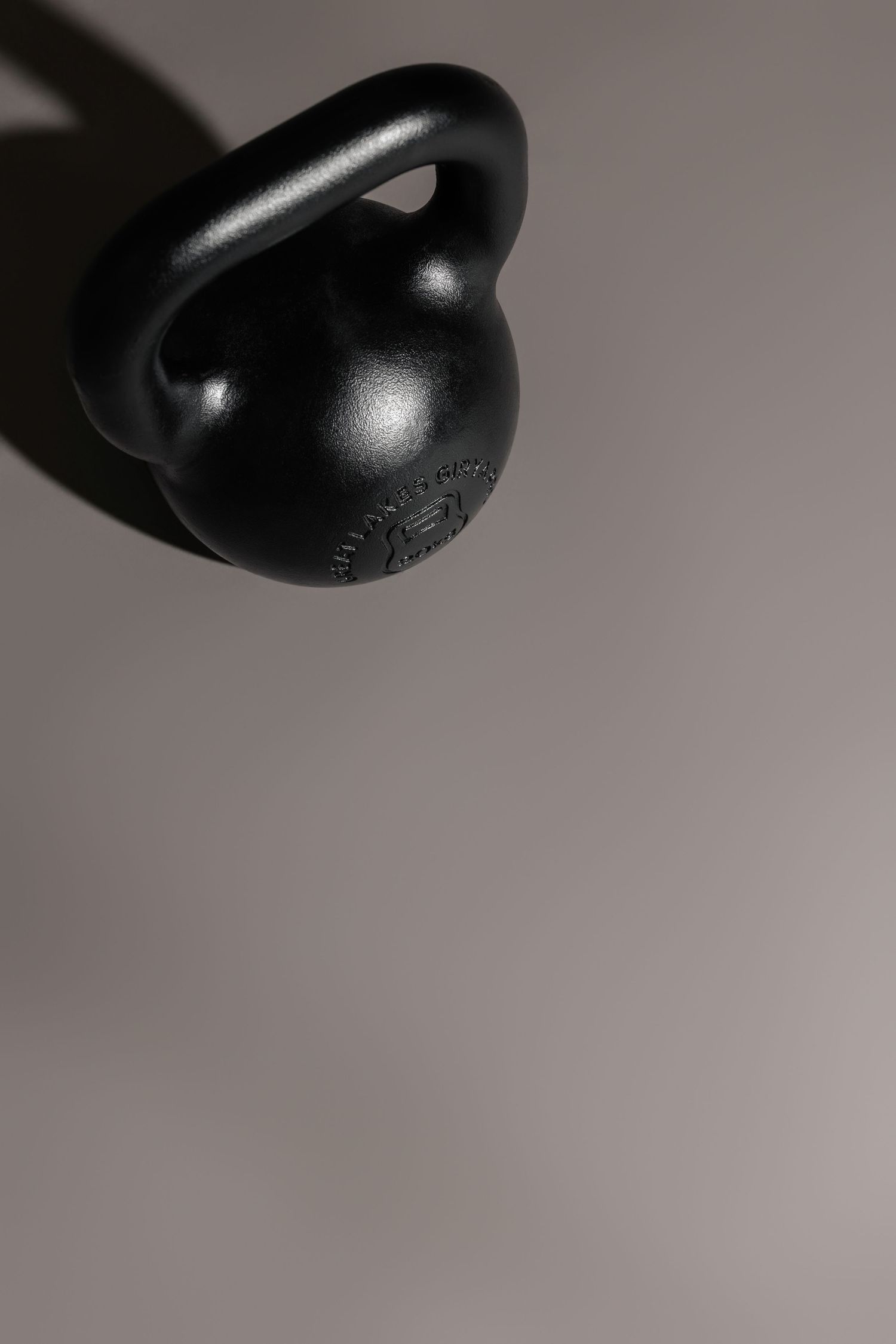 Artistic close-up of black kettlebell handle and surface texture.