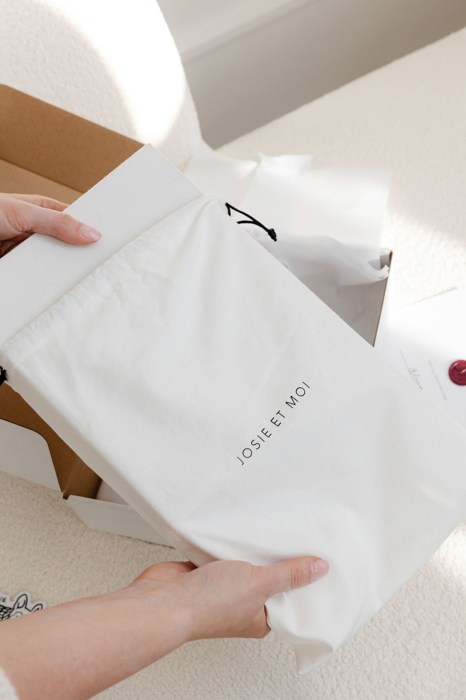 White retail packaging and tissue paper being unboxed against a light background.