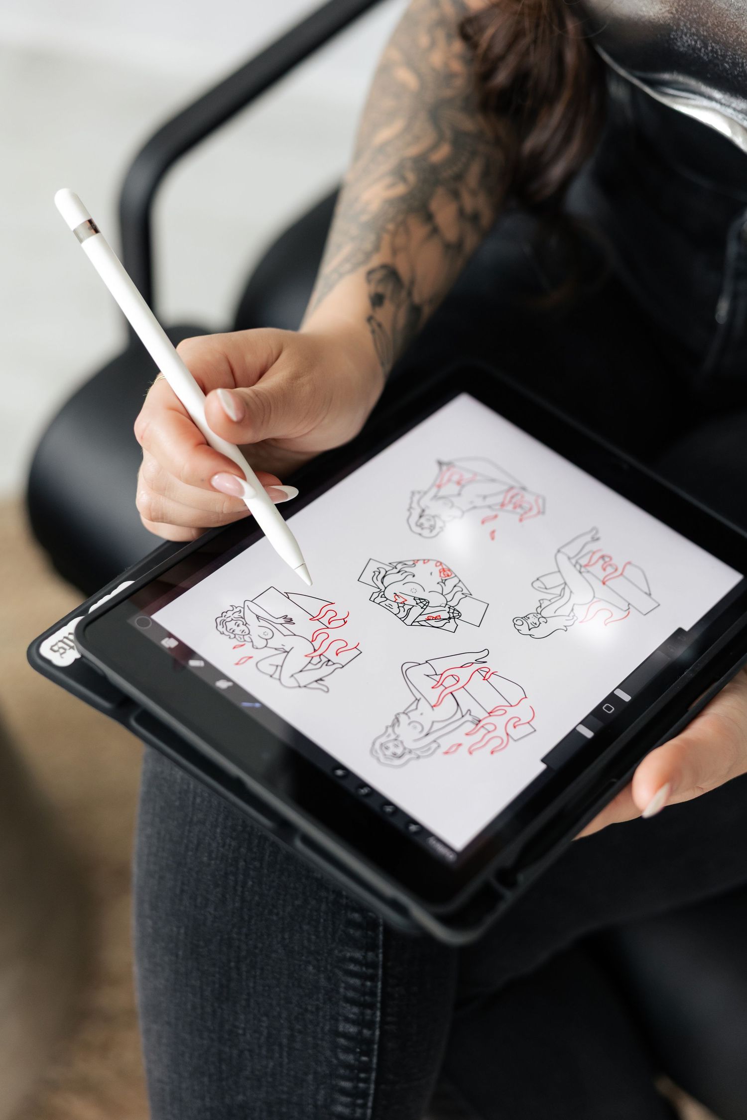 Digital sketching on a tablet with stylus showing character designs.