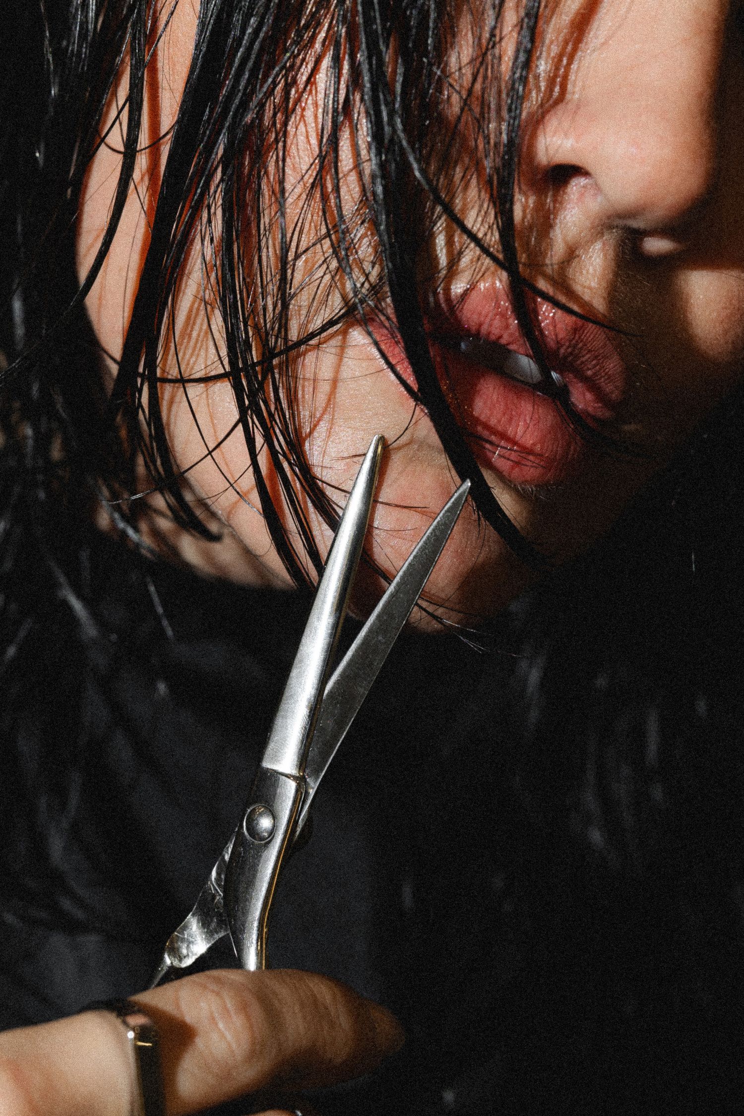 Close-up of hair styling tools being used on dark wet hair.