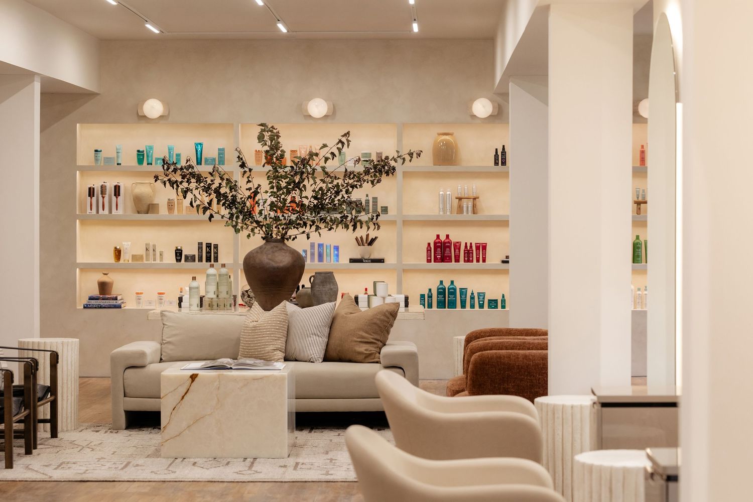 Spacious modern salon interior with white walls, wood floors and elegant styling stations.