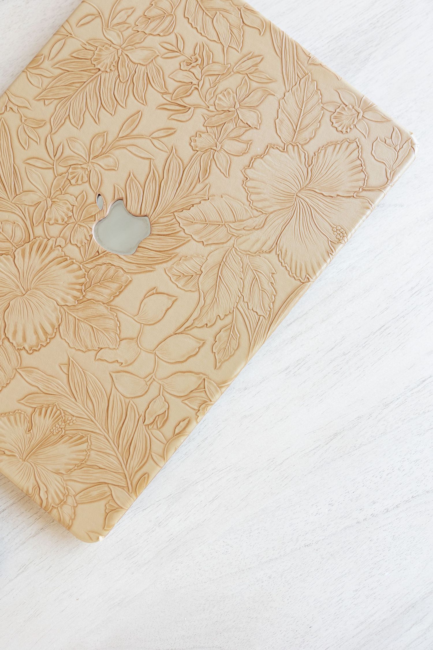 Beige floral pattern paper with delicate design on white surface.