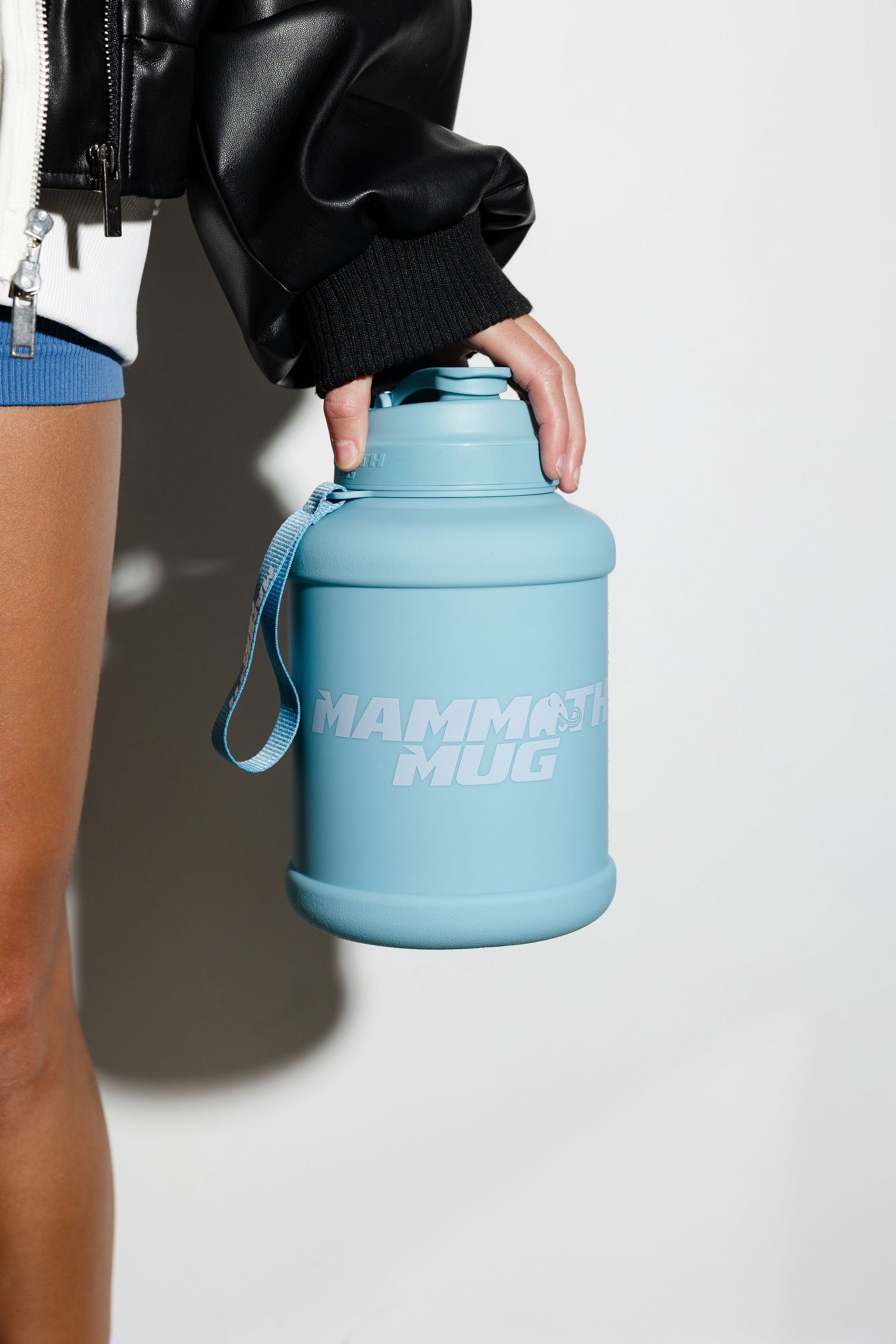 Close-up of light blue water bottle with text branding against white background.