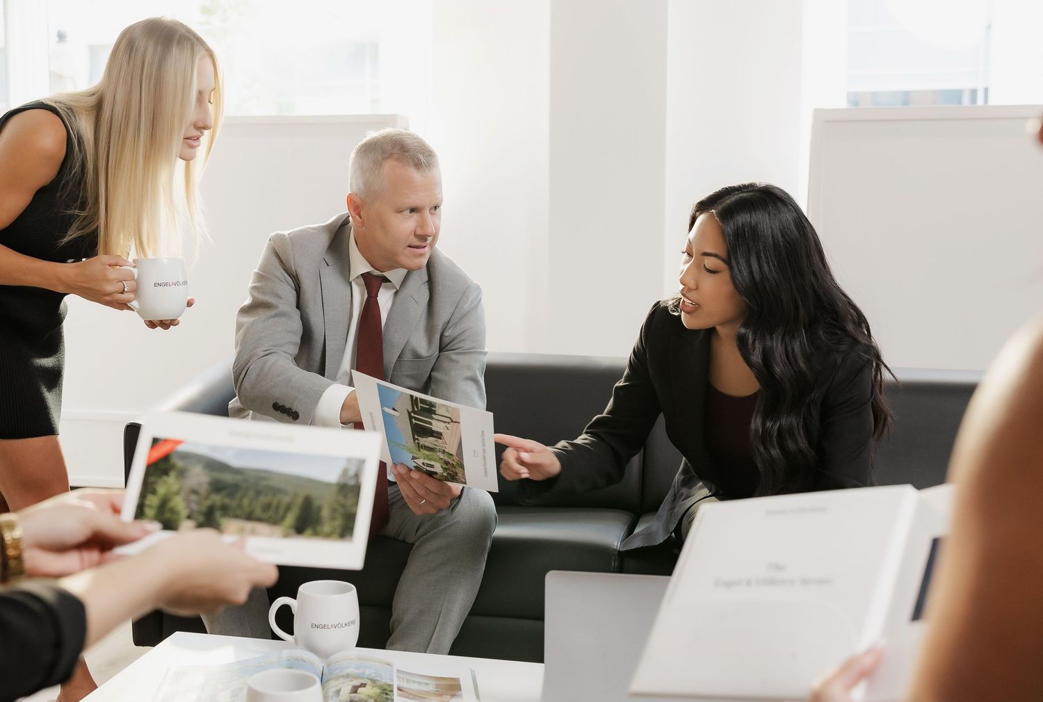 Business professionals reviewing documents during meeting in bright modern office.