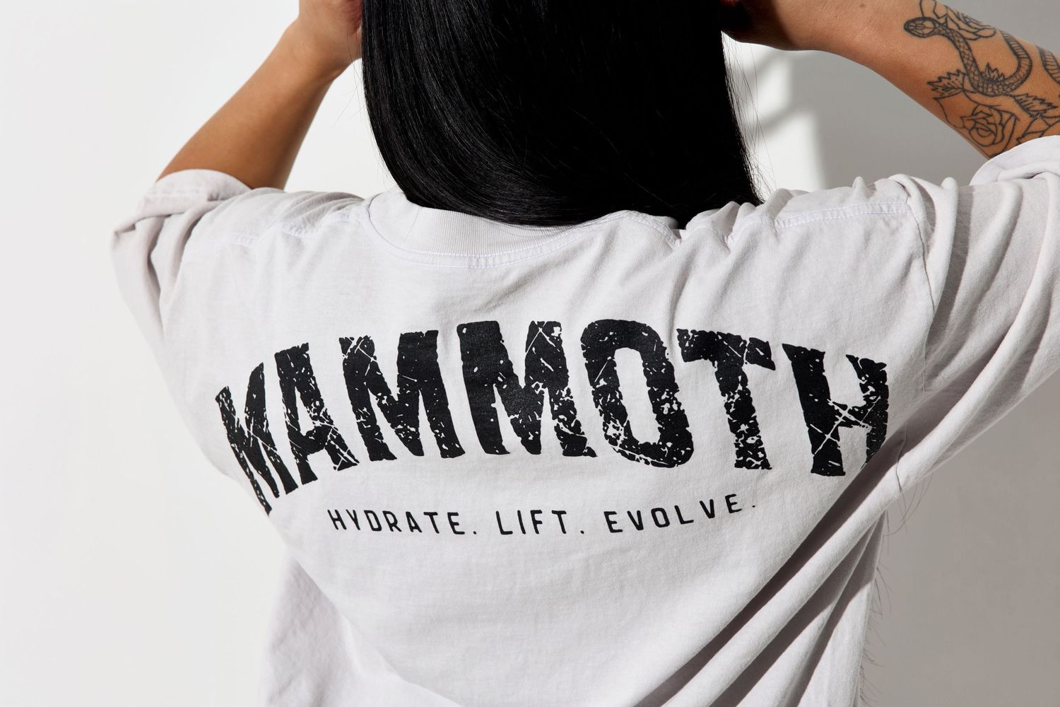 White Mammoth t-shirt with motivational text 'Hydrate Lift Evolve' displayed against white background.