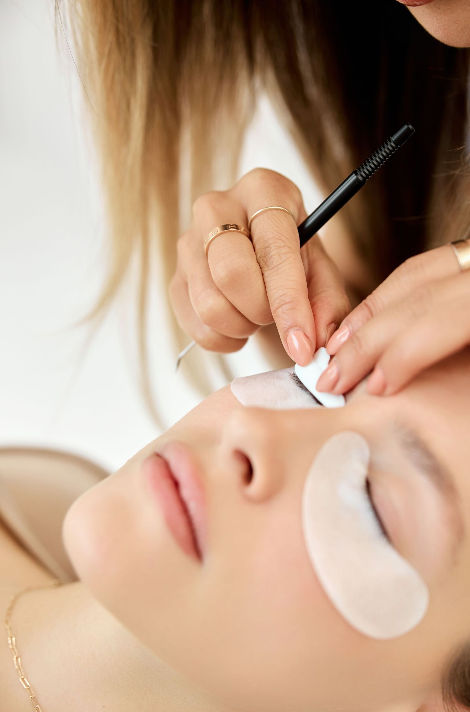 Close-up of an eyelash extension application procedure showing delicate placement of individual lashes.