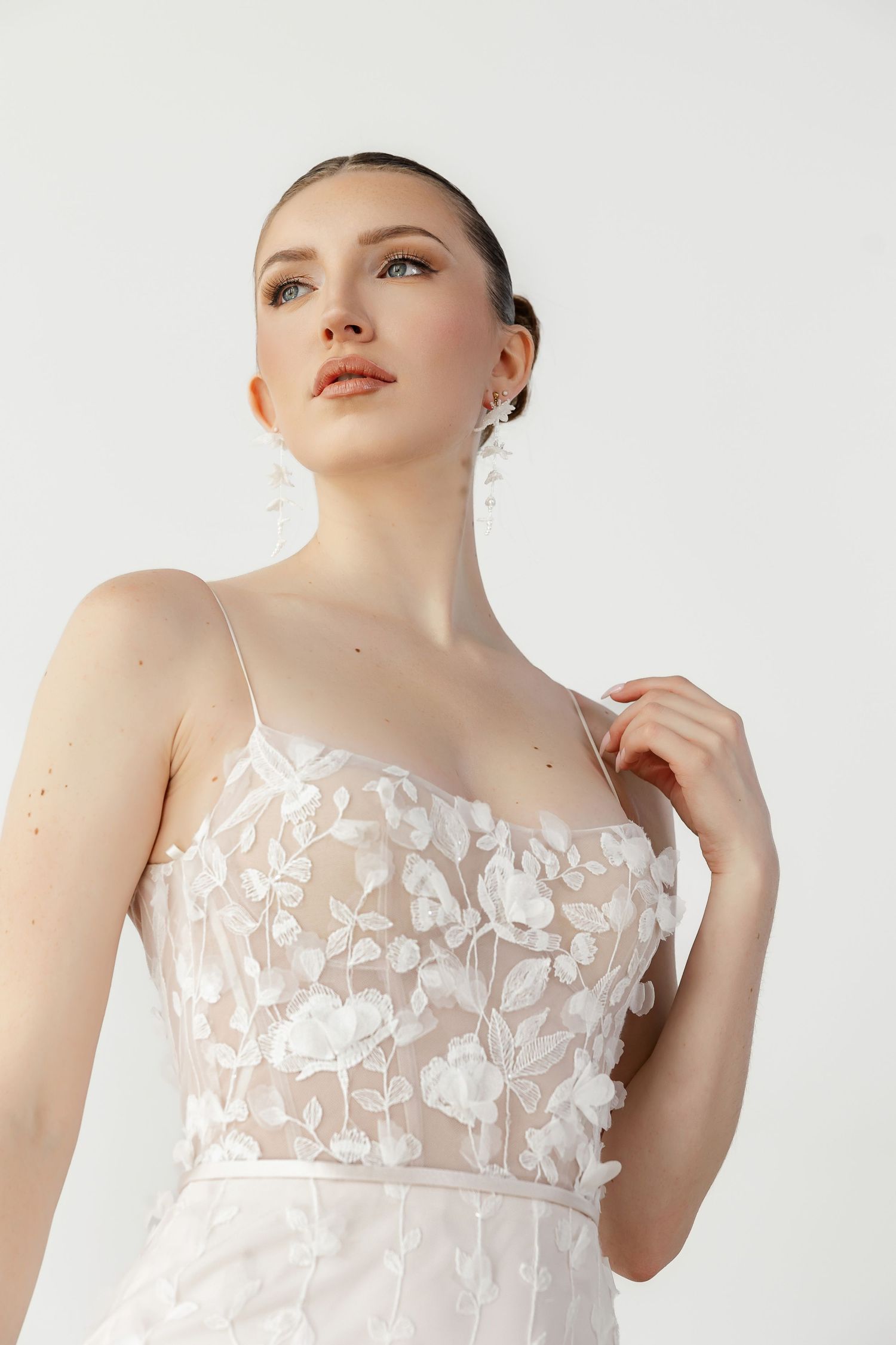 Delicate floral applique bodice wedding dress with sheer details shown in close-up views.
