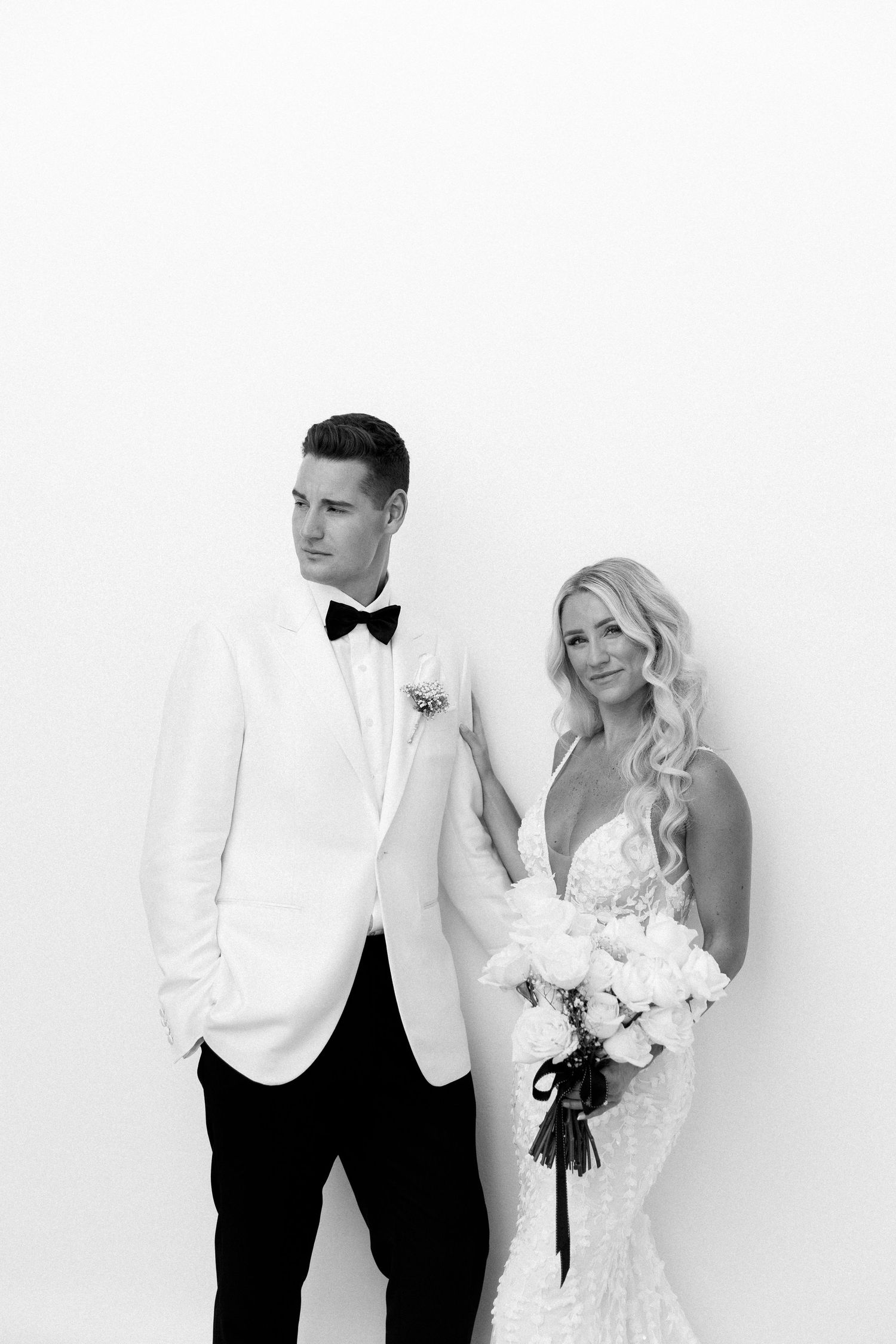 Elegant black and white wedding portrait with couple in classic formal attire.