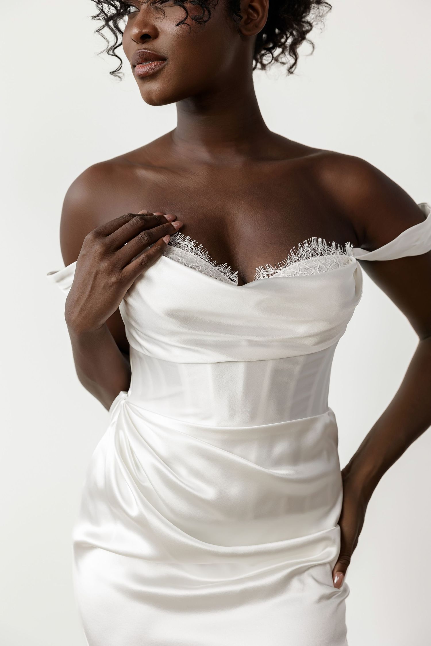 Strapless white satin wedding dress with draped bodice shown in close-up details.