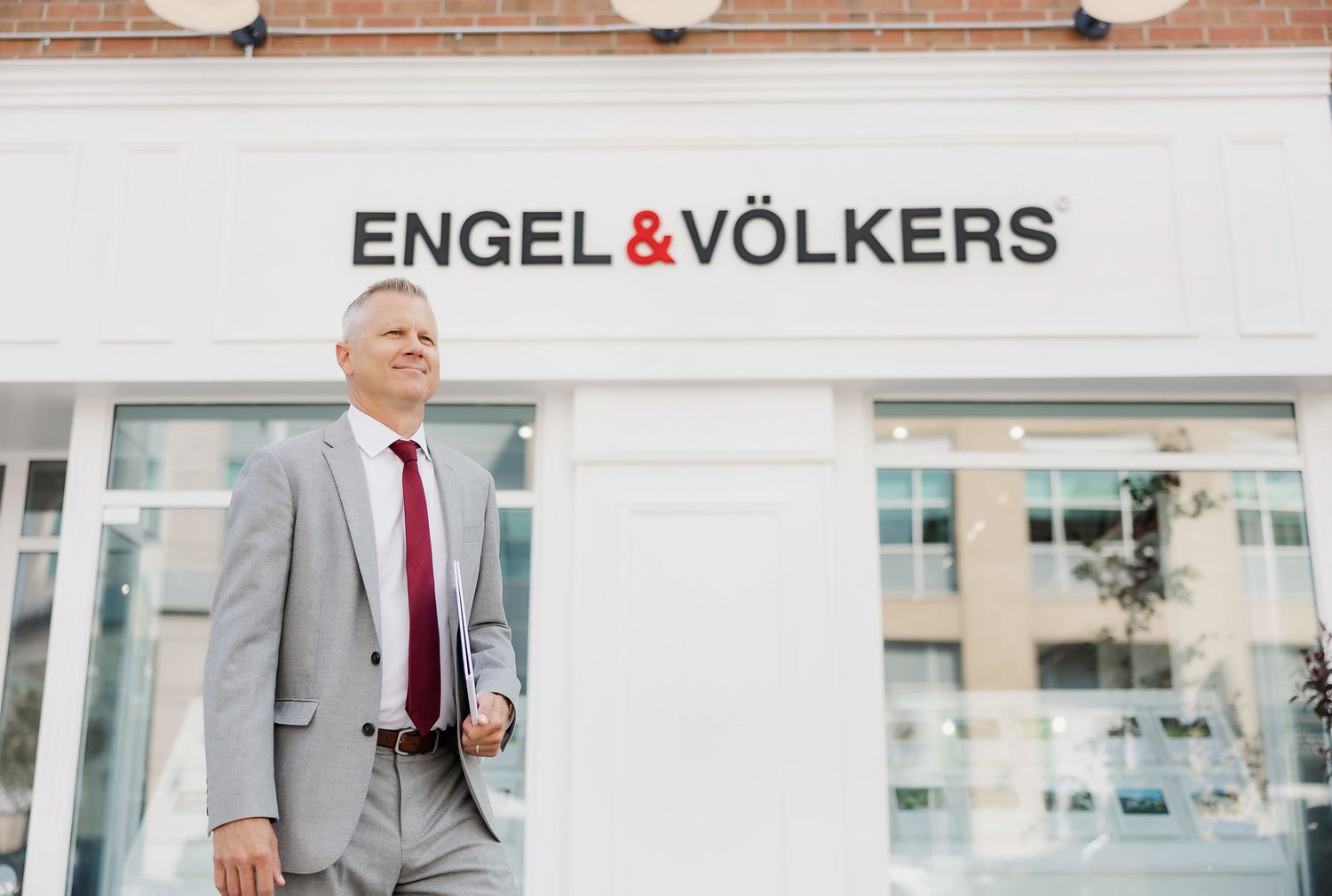 Exterior view of Engel & Volkers real estate office storefront.